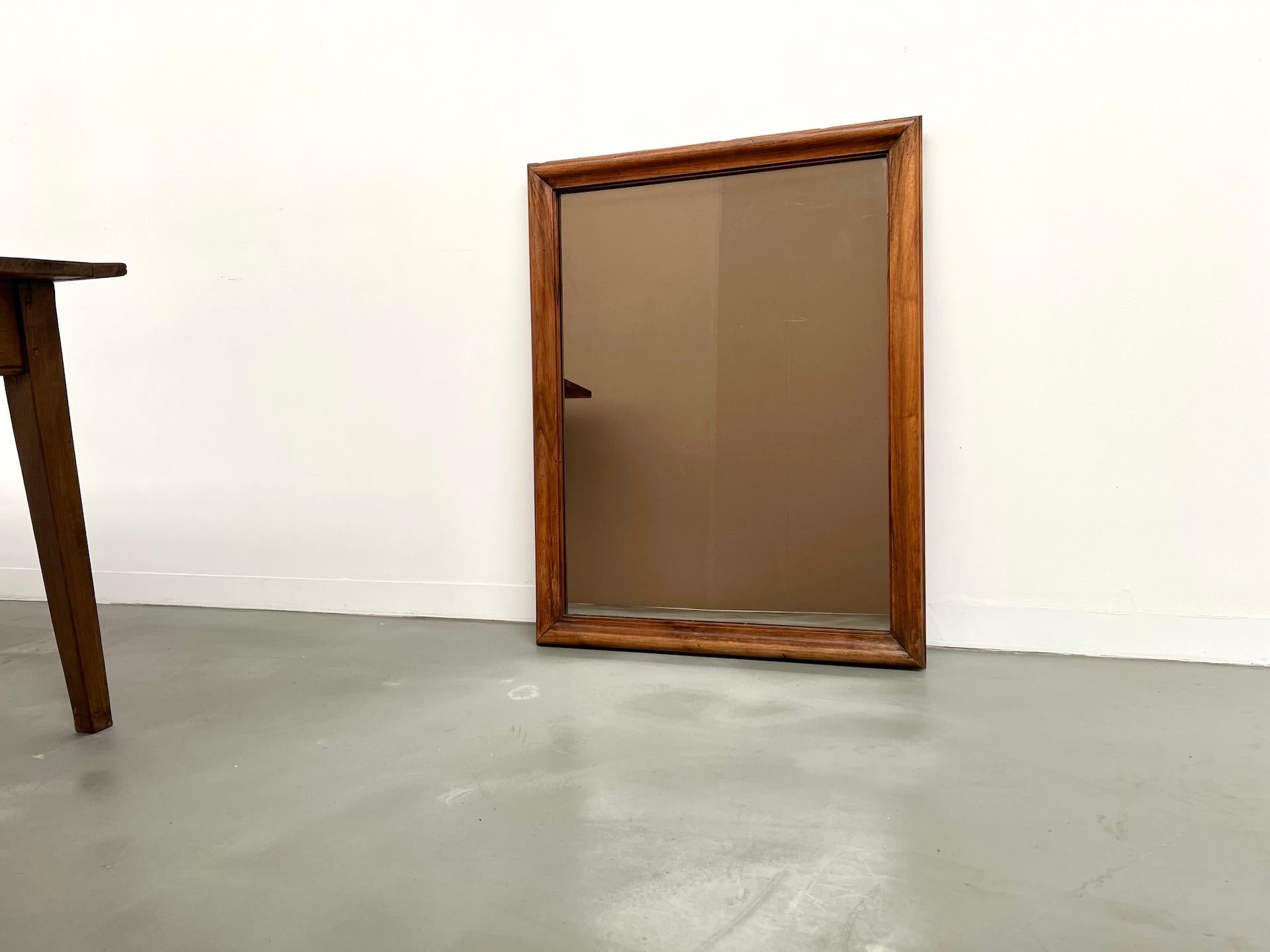Turn-of-the-century simplicity and charm.

Elegant mirror from the early 1900s in solid walnut, showcasing a rich grain and soft patina.

The beveled frame is both understated and refined, highlighting the natural beauty of the wood.

The original