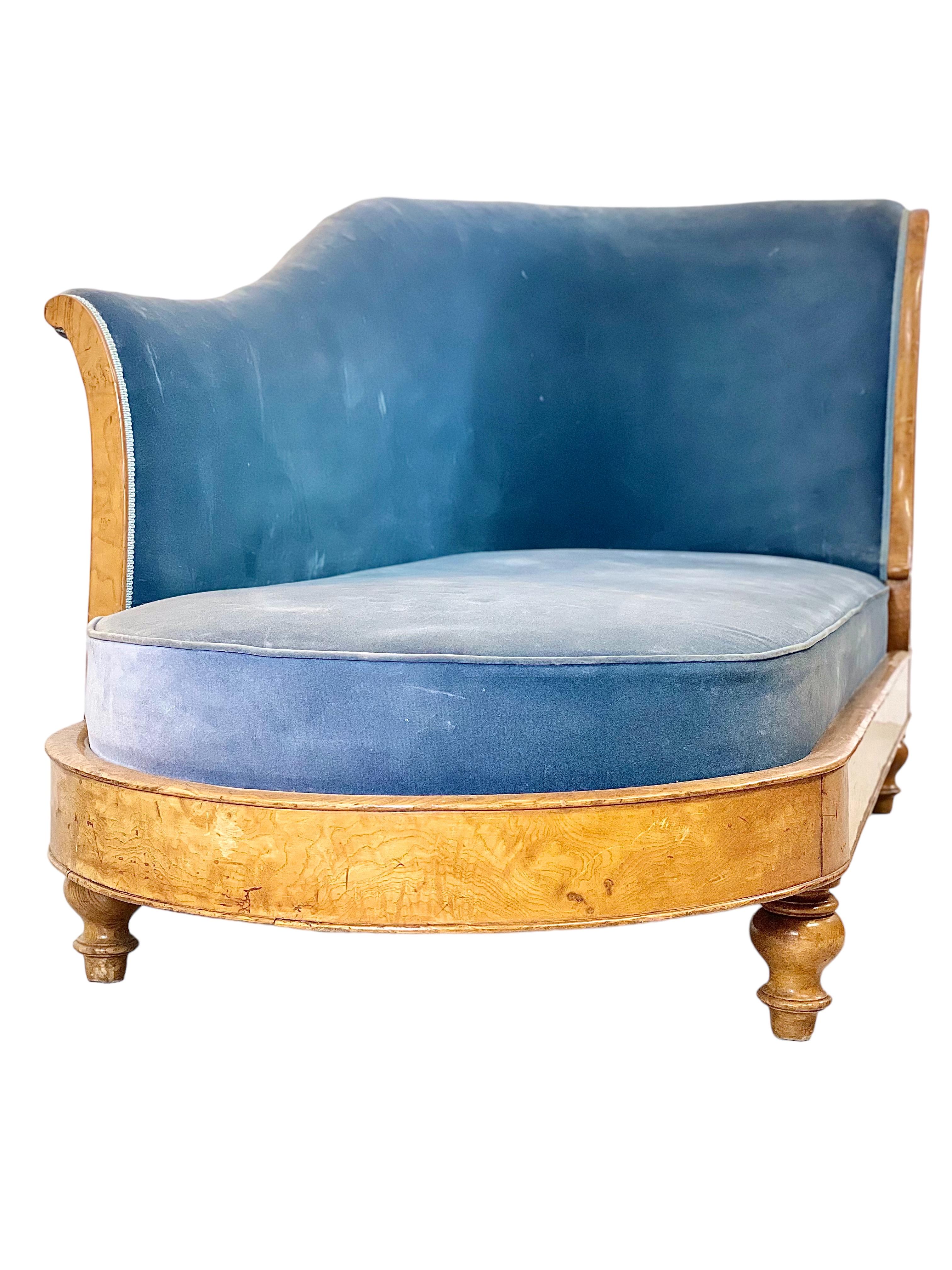 An eye-catching Charles X ‘Méridienne’ sofa, upholstered in blue velvet. The frame is finished in a light-coloured wood veneer, which highlights the simple but elegant design of the wraparound apron, with only a single palmette adorning its front