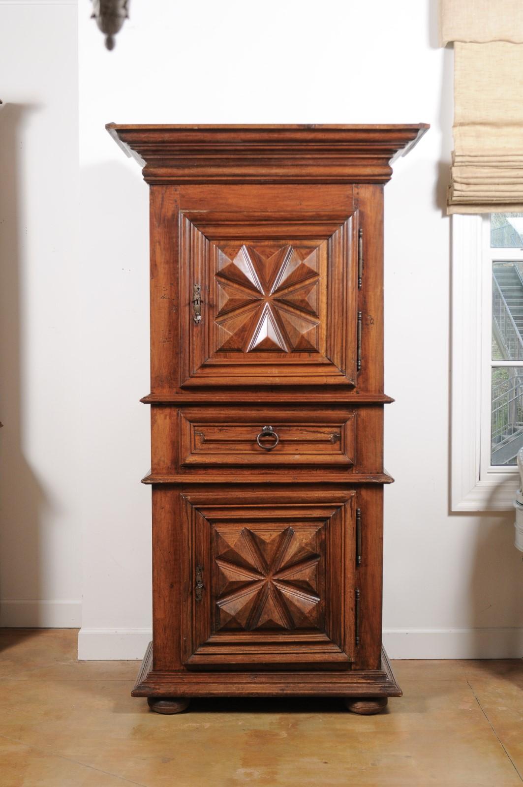 A French Louis XIII style walnut bonnetière from the mid-18th century, with two doors, central drawer and original hardware. Born in France during the 1750s, this walnut cabinet showcases the stylistic characteristics of the Louis XIII era. A large