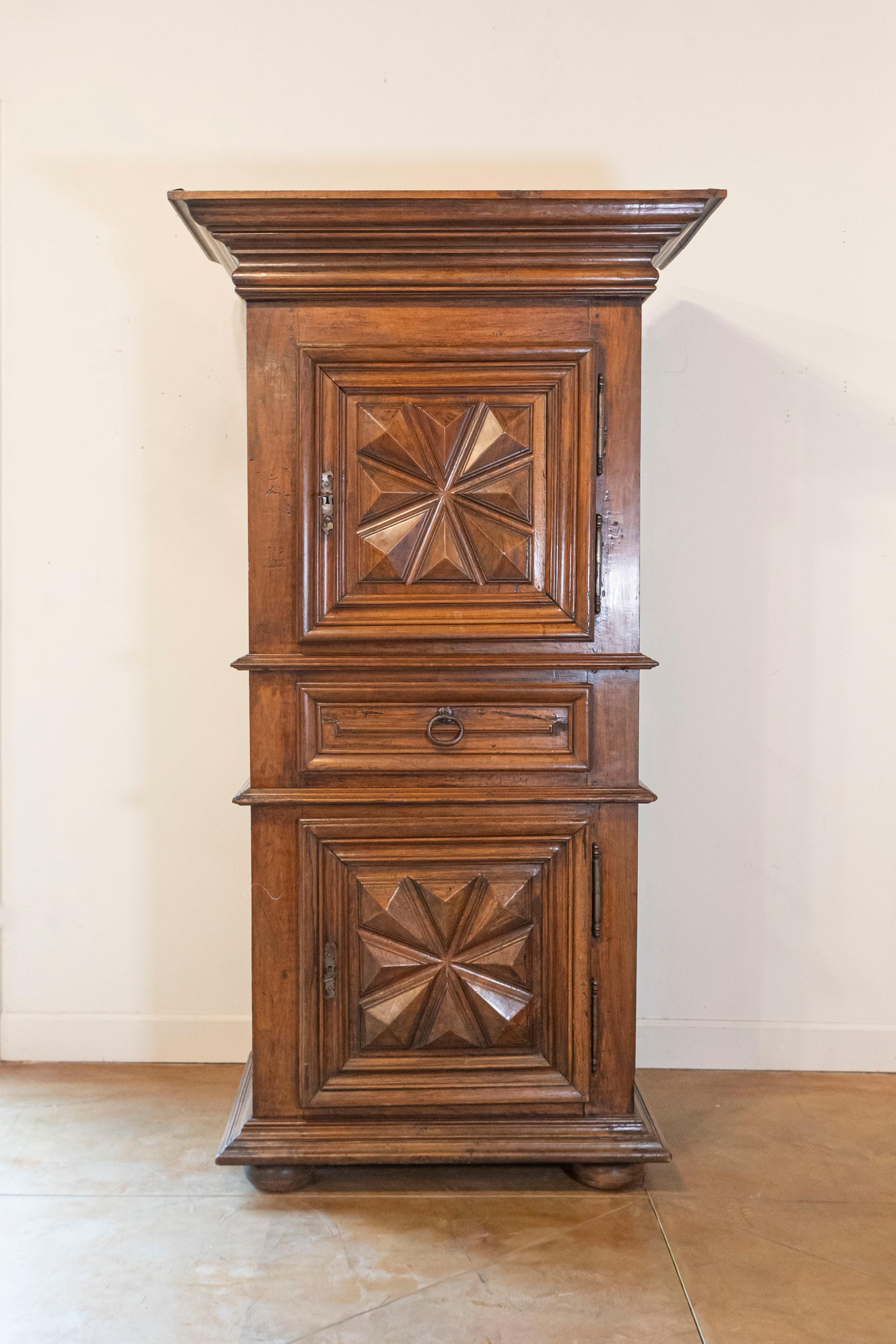 Bonnetière française en noyer de style Louis XIII, datant du milieu du XVIIIe siècle, avec deux portes, un tiroir central et des ferrures d'origine. Née en France dans les années 1750, cette armoire en noyer présente les caractéristiques