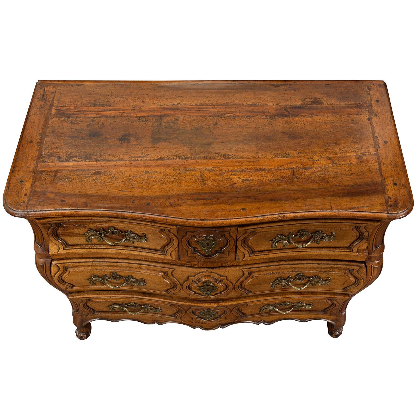 A superb quality French mid 18th Century Louis XV period walnut commode with bronze hardware. The serpentine shaped commode is elegantly raised by cabriole legs which lead to the wonderful scalloped frieze. The commode has two large drawers below