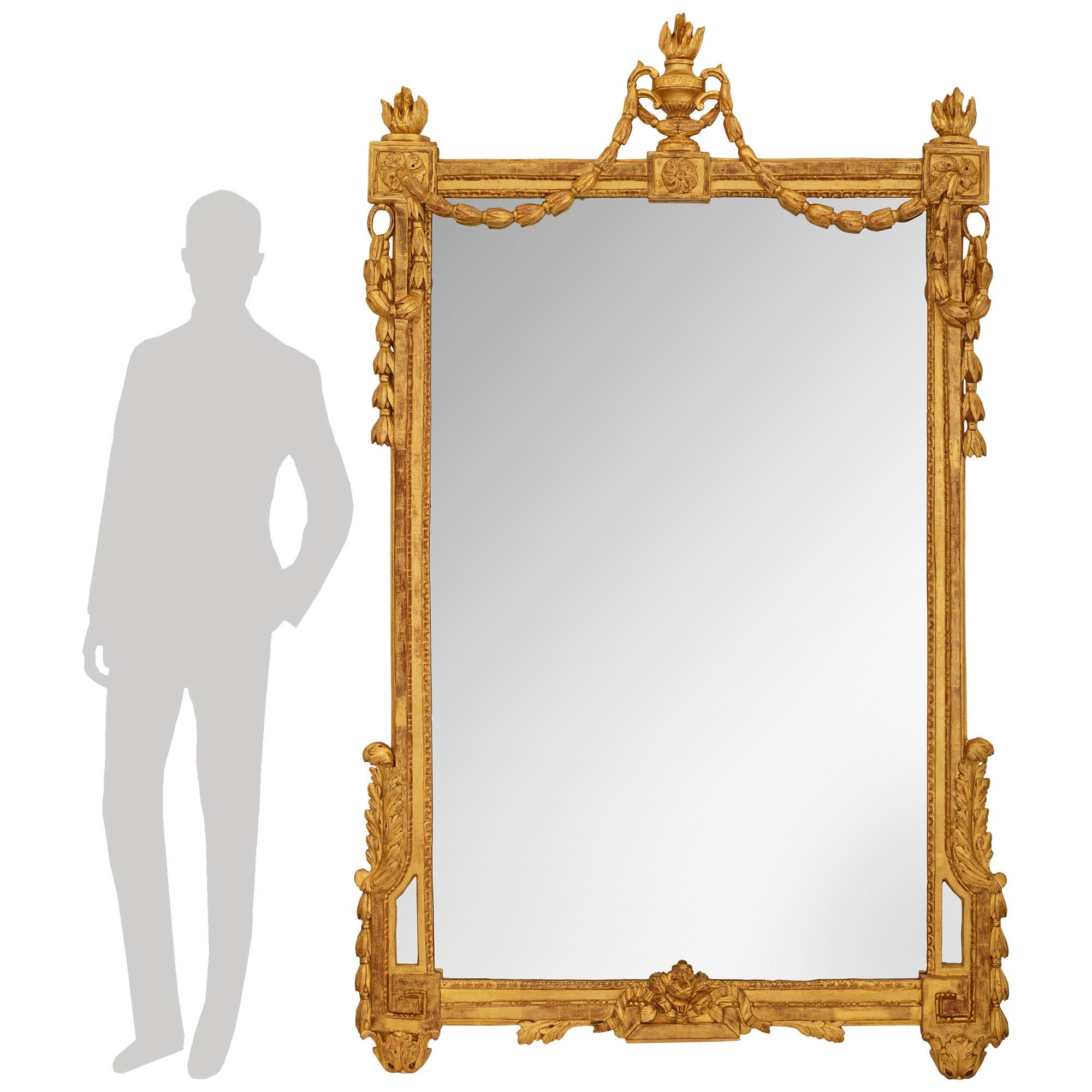 A wonderful and richly detailed French mid 18th century Louis XVI Period Giltwood mirror. This stunning mirror is raised on most decorative acanthus leaf supports below Greek Key accented blocks and foliate garlands leading up each side. The bottom