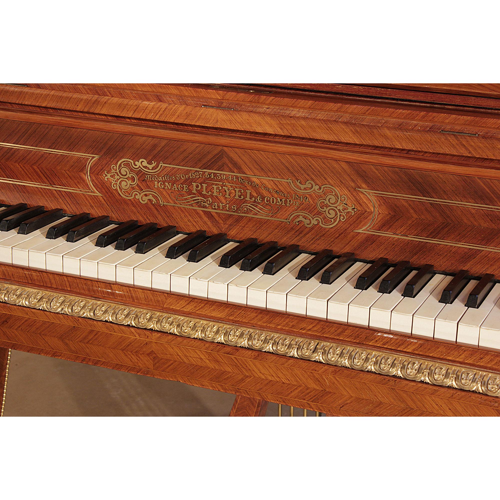 A spectacular French mid-19th century, circa 1855, Louis XVI st. tulipwood parquetry and ormolu mounted, Model 2 Concert Grand Piano, signed Pleyel, Serial Number 21731. The pianoforte is raised on three tapered concave top legs with beaded ormolu