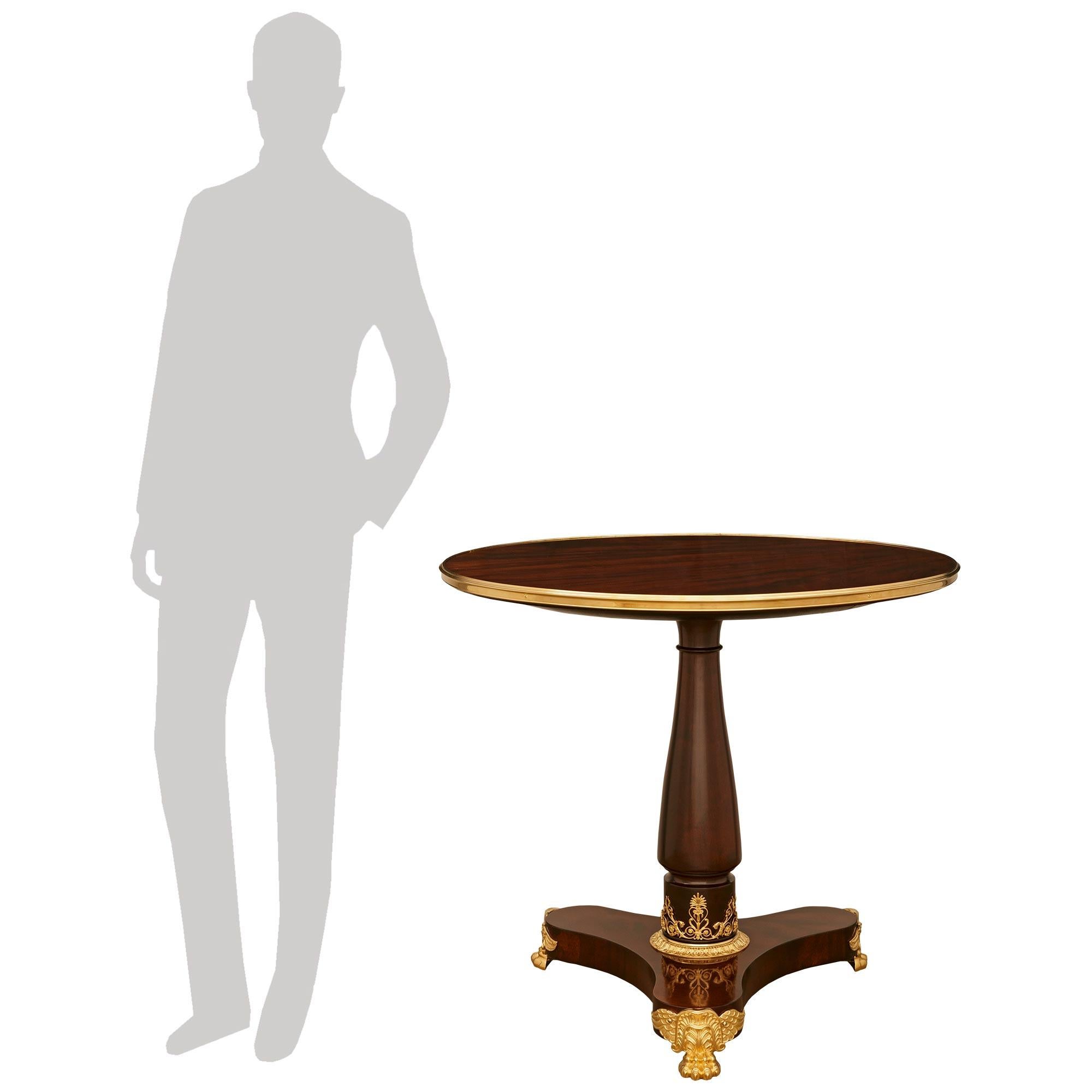 A most attractive and very high quality French mid 19th century Empire st. Mahogany and Ormolu side/center table. This handsome table is raised by a triangular base with concave sides all above impressive Ormolu pawed and winged supports. The
