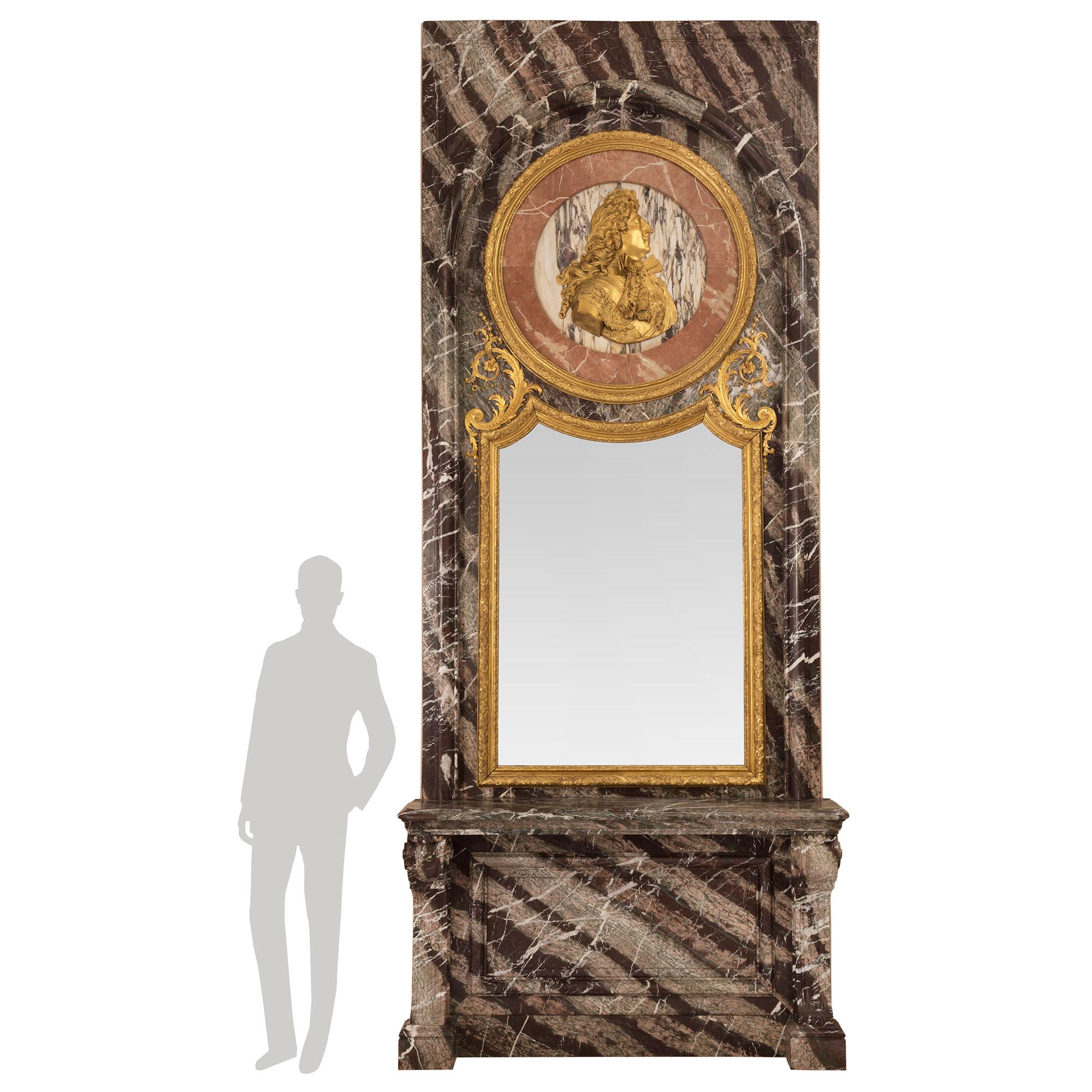 Magnifique console de style Louis XIV du milieu du XIXe siècle en bronze doré, bois doré, Campan Rubané, Rose Vif et Fleur de Pêcher et miroir assorti. D'une hauteur de plus de douze pieds, cette console des plus impressionnantes est soutenue par