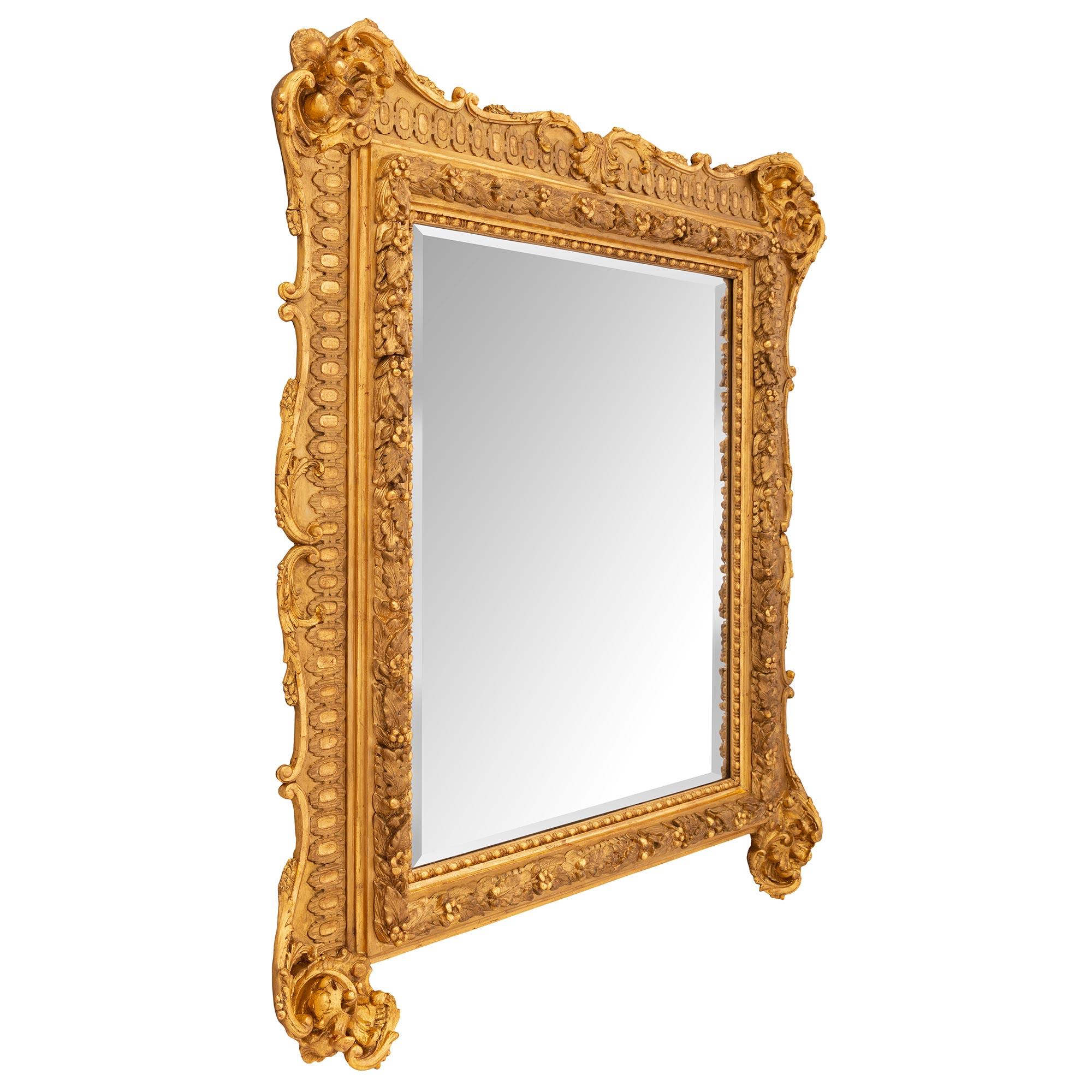 An impressive and most decorative French mid 19th century Louis XV st. giltwood mirror. The mirror retains its original beveled mirror plate set within a most elegant mottled frame with a fine beaded and fluted wrap around band. A striking richly