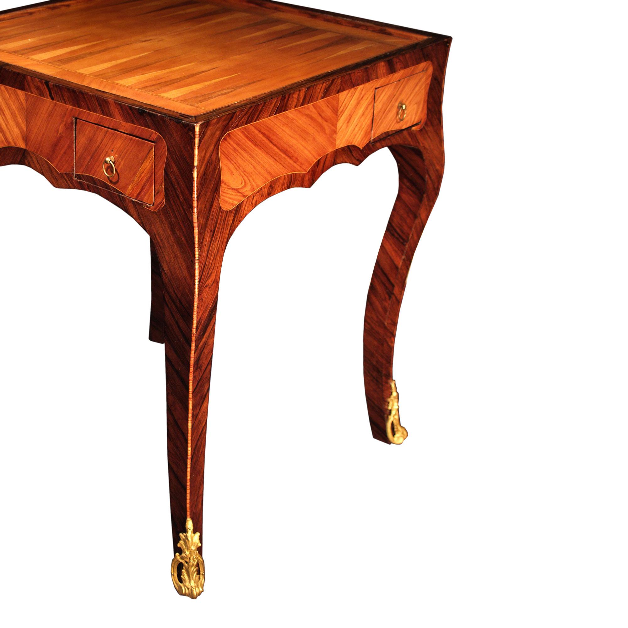 A unique scale French mid 19th century Louis XV st. tulipwood and kingwood marquetry games table. The table is raised on canriole legs with pierced ormolu sabots. At the scalloped frieze are four drawers, one on each side. On top lays a backgammon