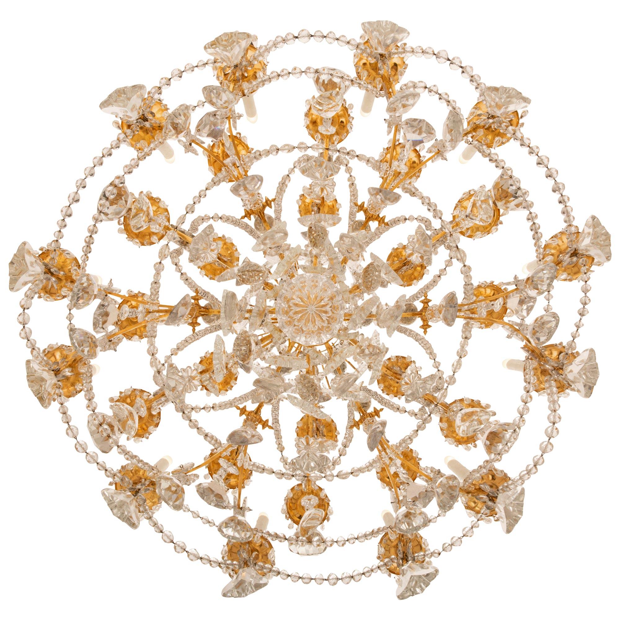 A sensational and grand scaled French mid 19th century Louis XV st. Ormolu and Baccarat crystal chandelier. The thirty light chandelier with a striking crystal central fut is surrounded by six central supporting scrolled arms which split at the