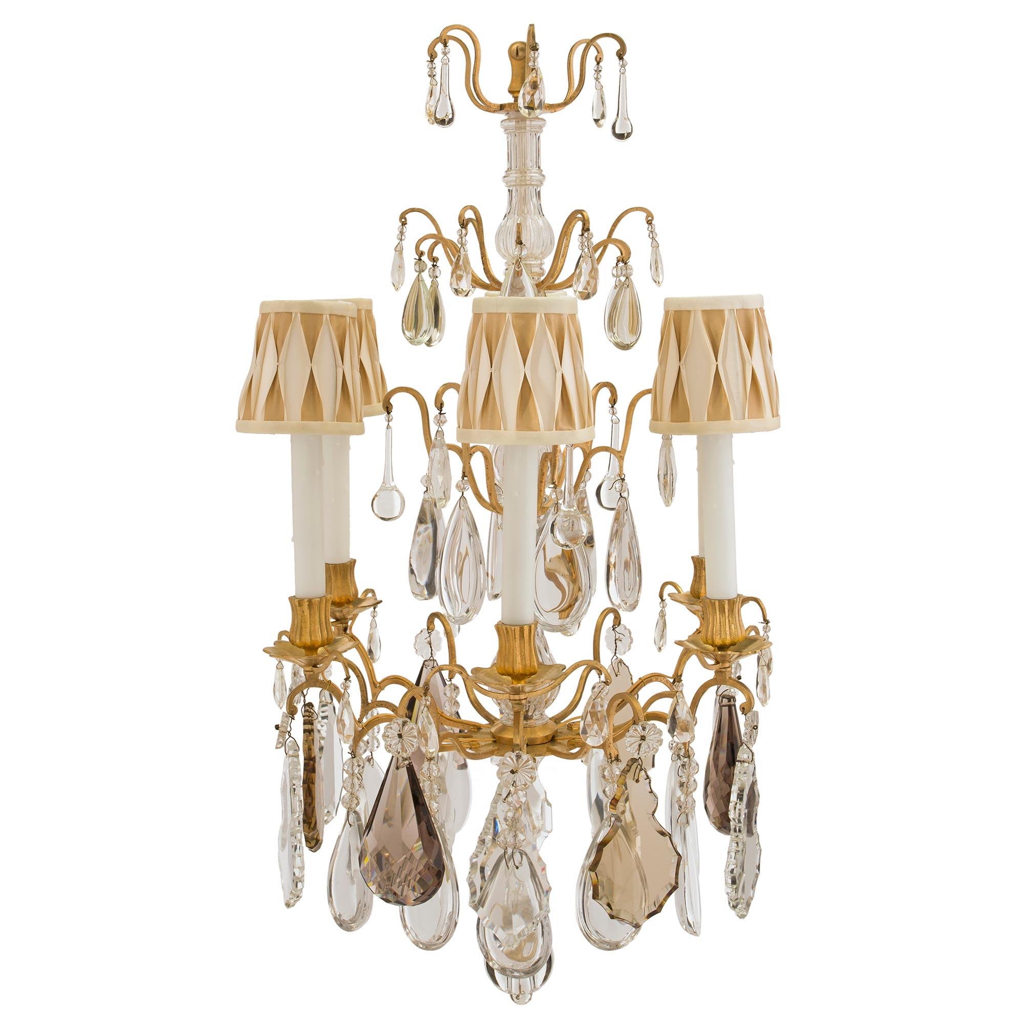A most elegant French mid 19th century Louis XV st. Baccarat crystal and ormolu six arm chandelier. The chandelier has an open cage with a reeded crystal central fut. A the bottom are the six electrified scrolled arms. Each are heavily adorned by