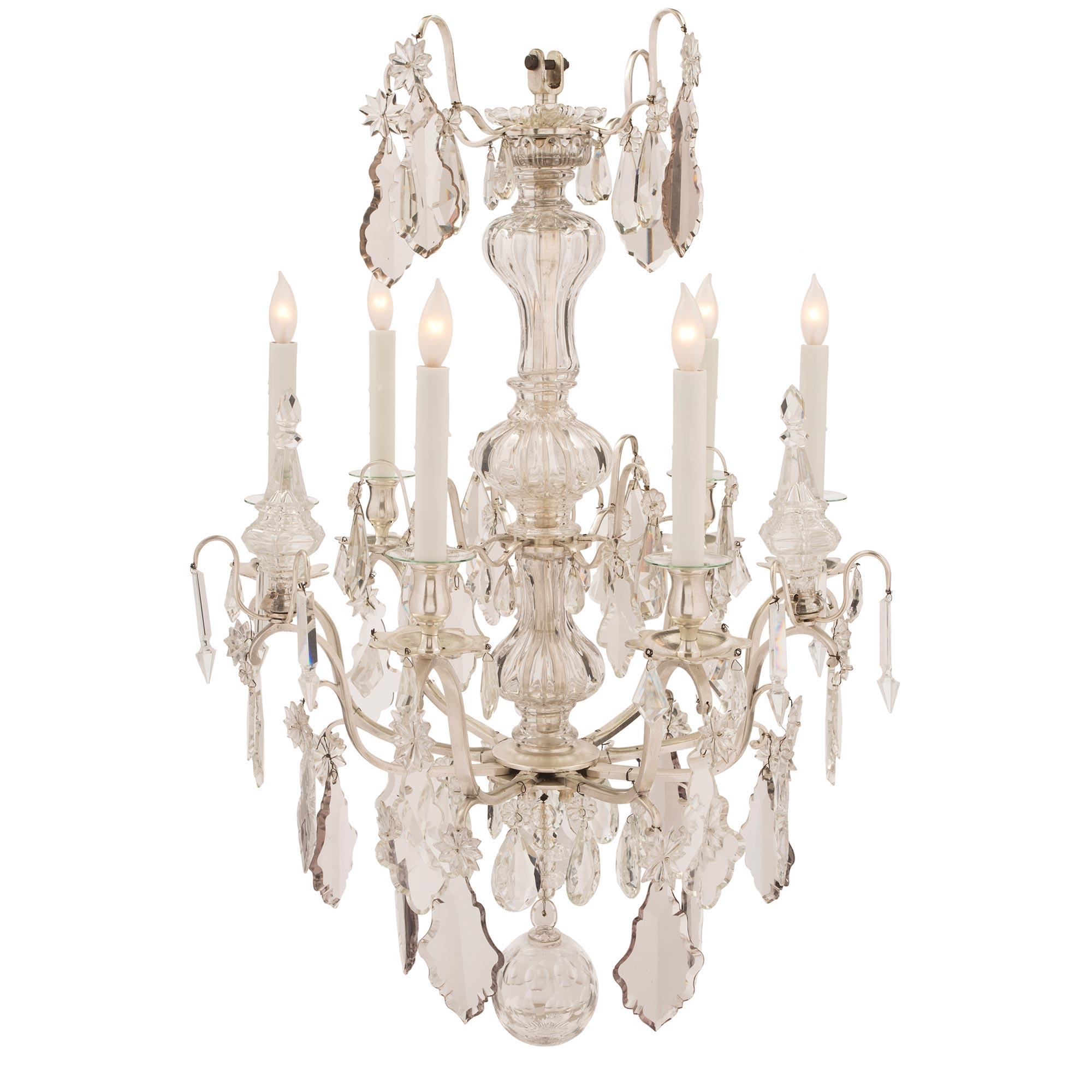 A very attractive and high quality French mid 19th century Louis XV st. silvered bronze and Baccarat crystal, six electrified arm chandelier. The chandelier has an elegant central crystal fut and nine 'S' scrolled arms. The arms are decorated by