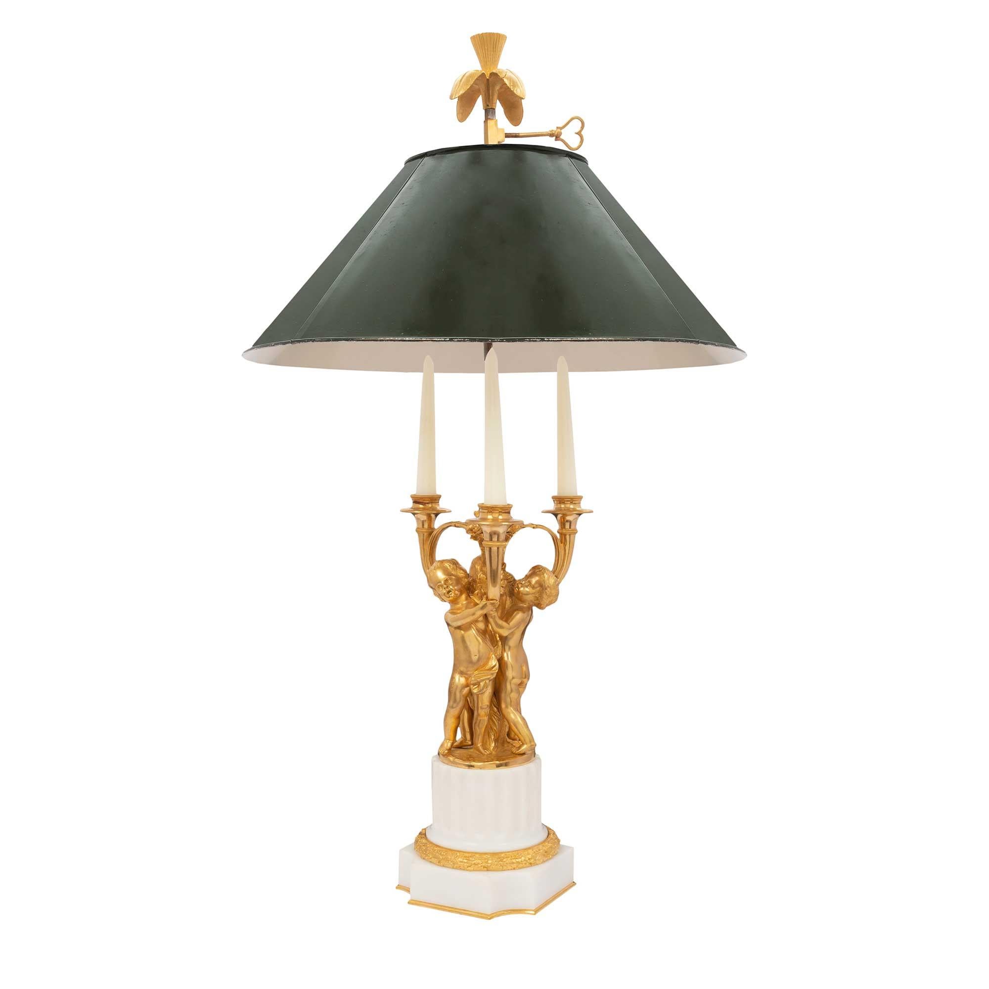 A lovely French mid 19th century Louis XVI st. ormolu and white Carrara marble candelabra mounted into a Bouillotte lamp. The square marble base with concave sides is richly chased with an ormolu berried wreath and raised by a circular fluted marble