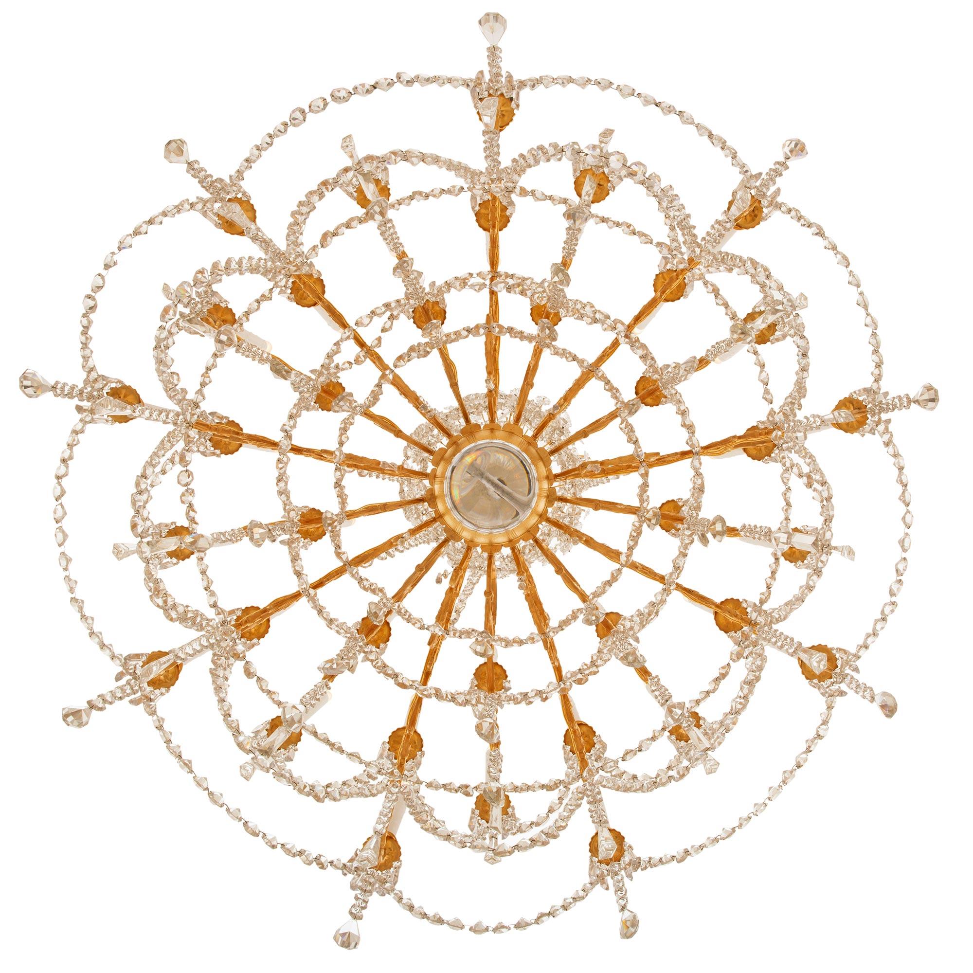 A spectacular and high very quality French mid 19th century Louis XVI st. ormolu and Baccarat crystal chandelier. The thirty-six arm chandelier is centered by a beautiful solid bottom Baccarat crystal ball below a stunning array of most decorative