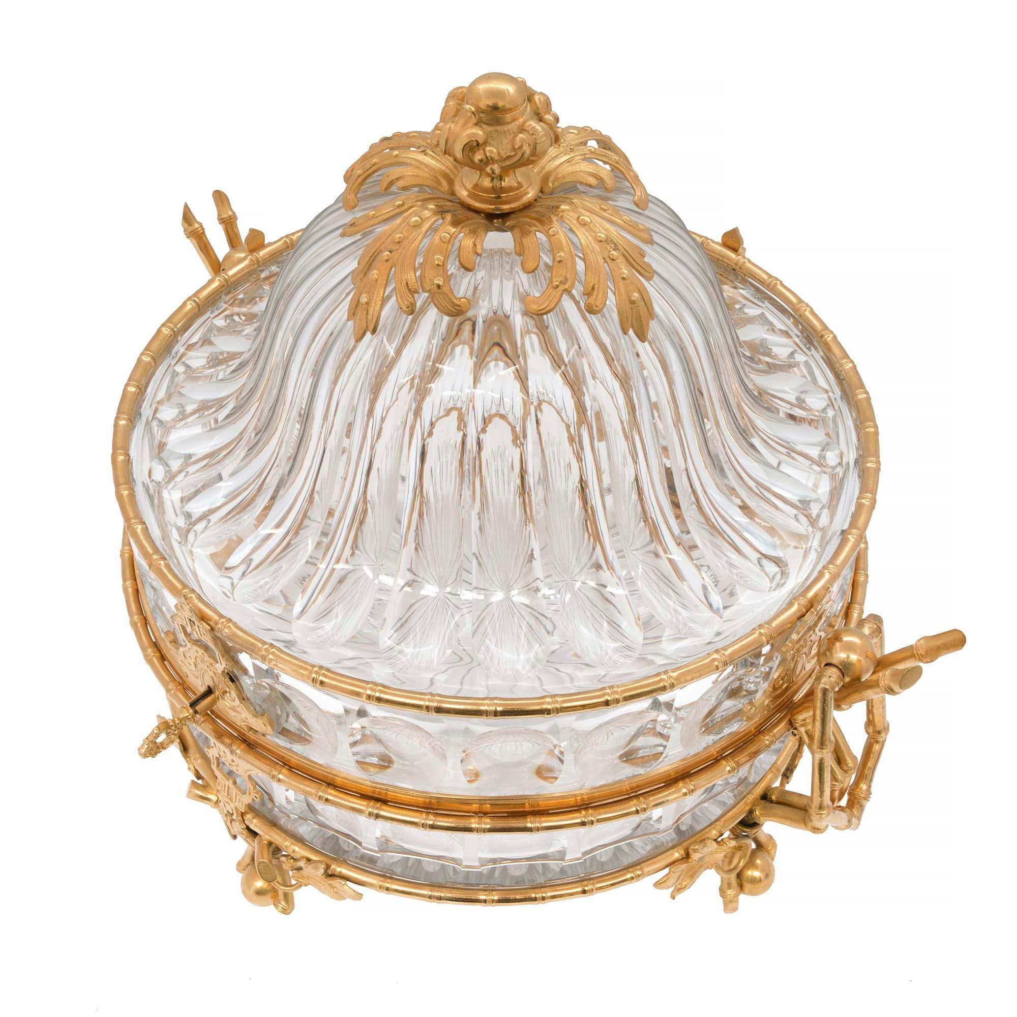 A beautiful and high quality French mid-19th century Louis XVI st. Baccarat crystal and ormolu centerpiece coffret inscribed BREVETE SGDG. The large scale box is raised by charming ormolu feet with a unique foliate, tied bamboo and ball design below