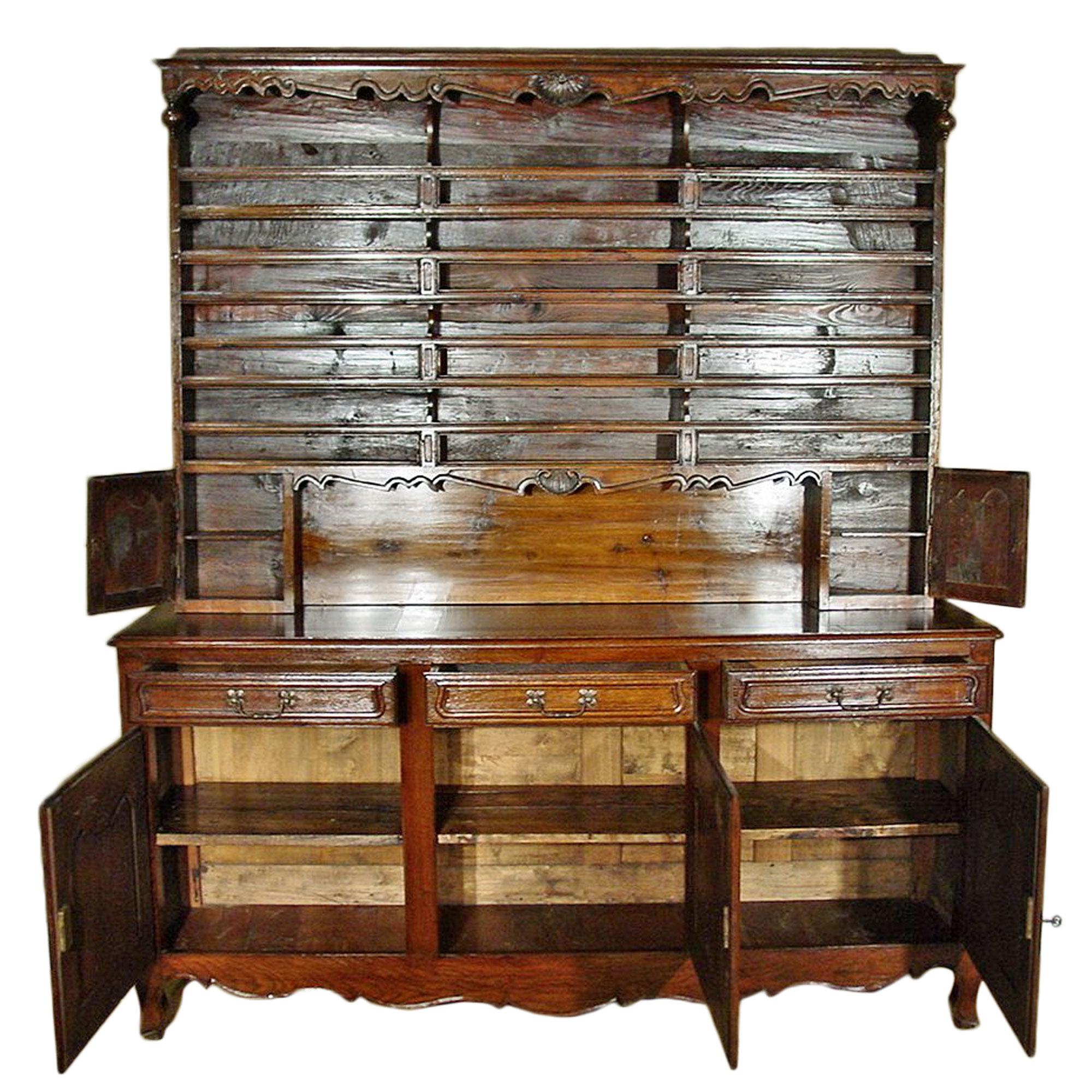 A charming country French mid 19th century Louis XVI st. oak 'Vaissellier'. The buffet has a scalloped apron below three doors with impressive original hardware. Above are three drawers. The doors and drawers all have a scrolled moulded design.