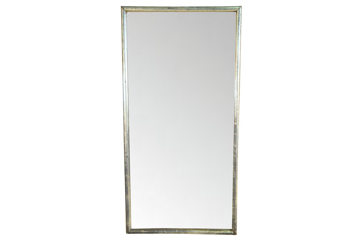 A very elegant and striking mid-19th century French mirror in silvered giltwood. The mirror retains its original mercury glass. Please note the glass in these photos has been photo shopped.