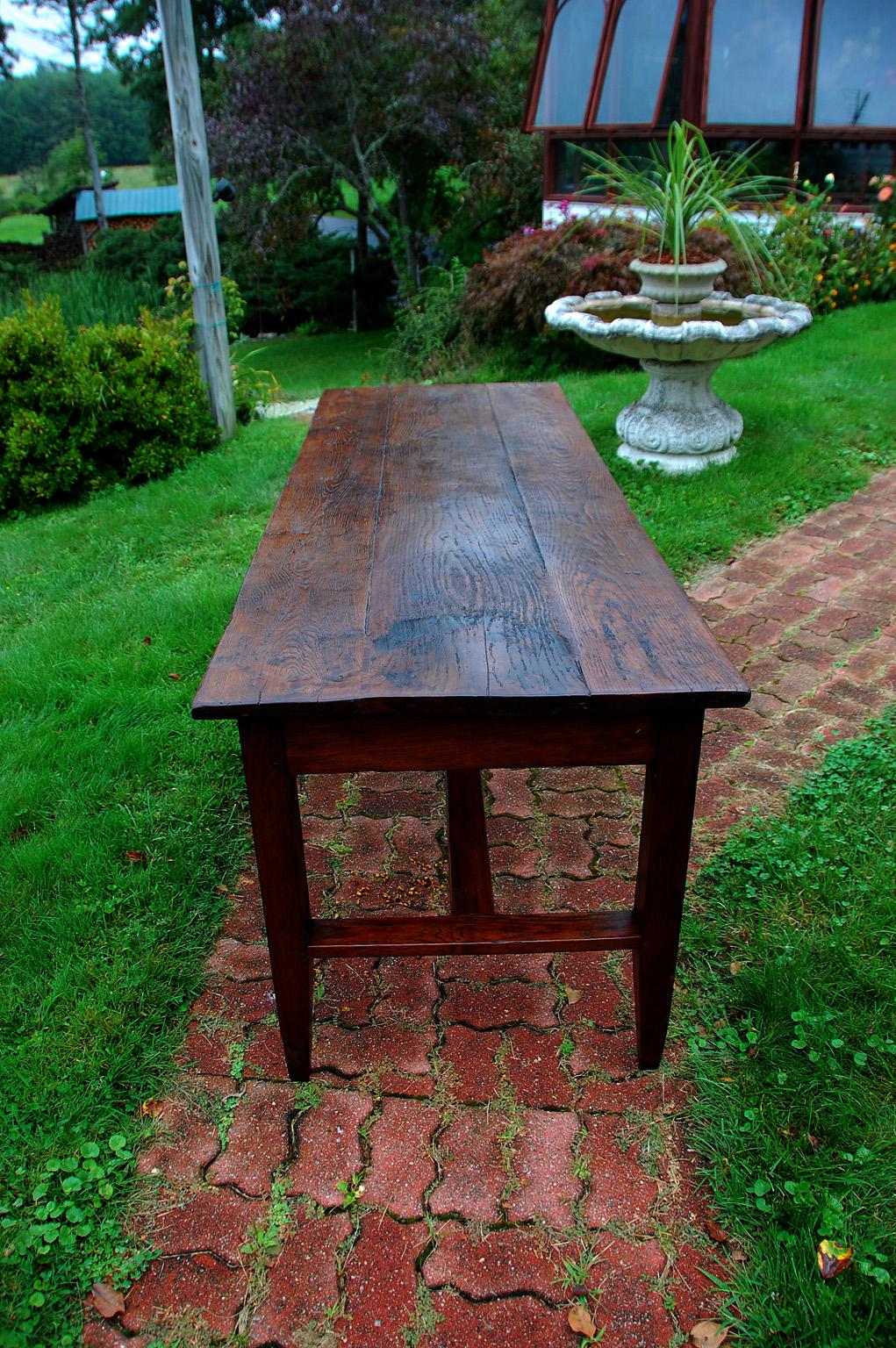 French mid 19th century provincial farmhouse table with H Stretcher, square tapered legs, and one drawer in the long side of the table. This 86 inch long country table came from the Burgundy region of France. It has a top of three substantial planks