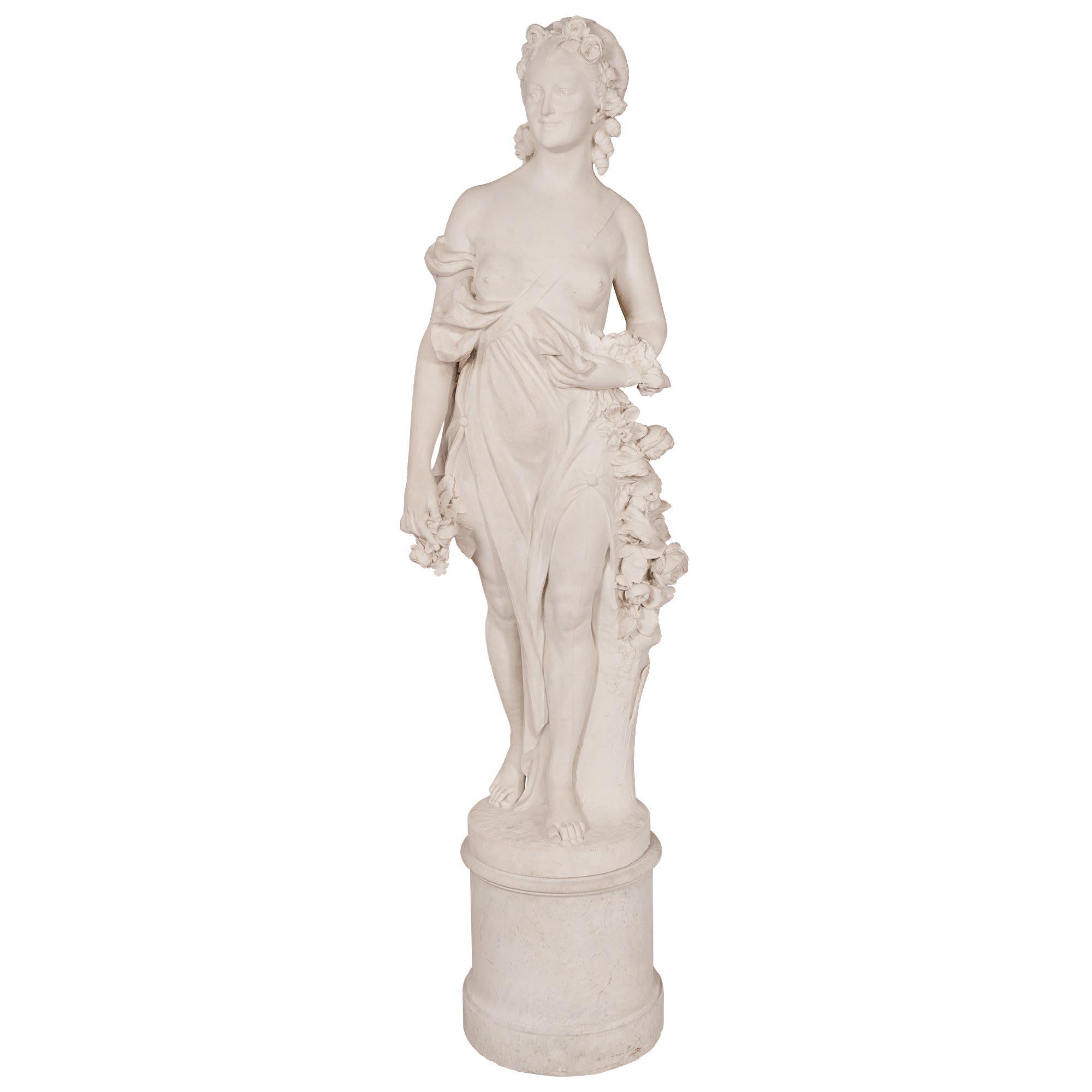 A sensational and monumentally scaled French mid 19th century white Carrara marble statue. The most impressive and statement making statue is raised by her original circular pedestal column which displays a fine mottled border. The high quality