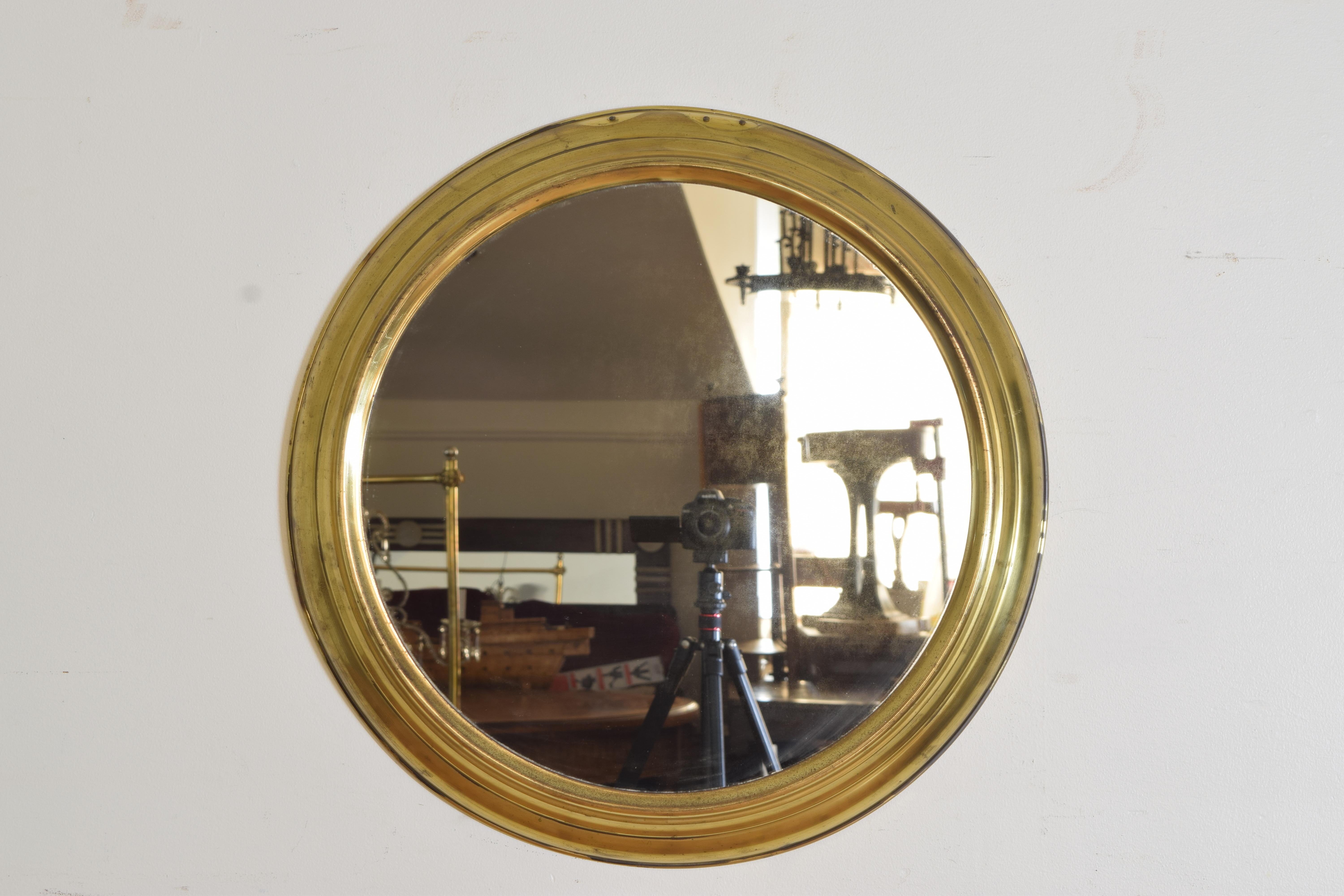 The circular convex cast brass frame with a molded edge, retaining original mirrorplate, projection of mirror is 2.5 inches.