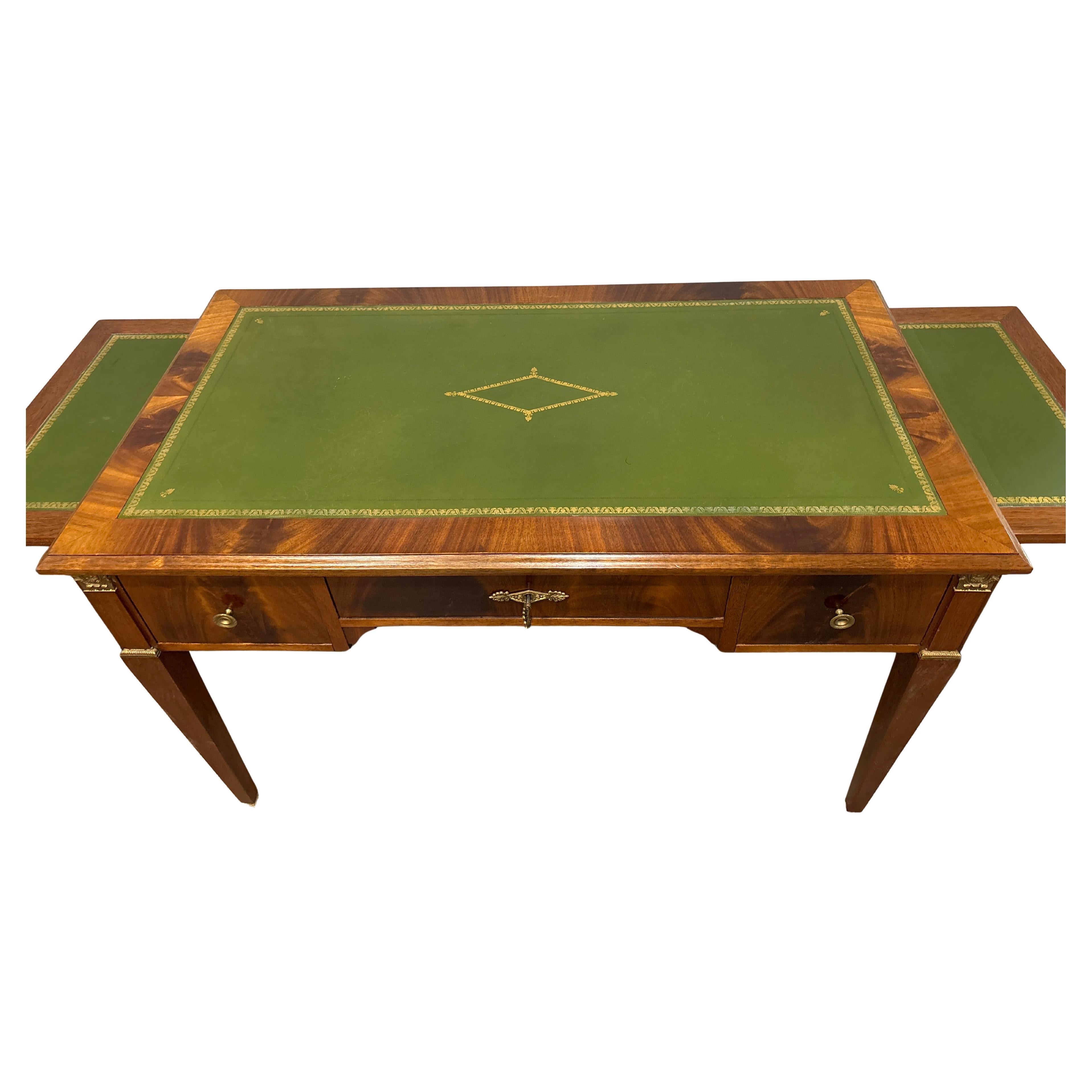 Questa magnifica scrivania ha un bellissimo mogano biondo fiammato con una pelle verde ricamata in oro. Ha 3 cassetti e 2 estensioni.
Con le due estensioni fuori, la lunghezza totale della scrivania è di 64,5