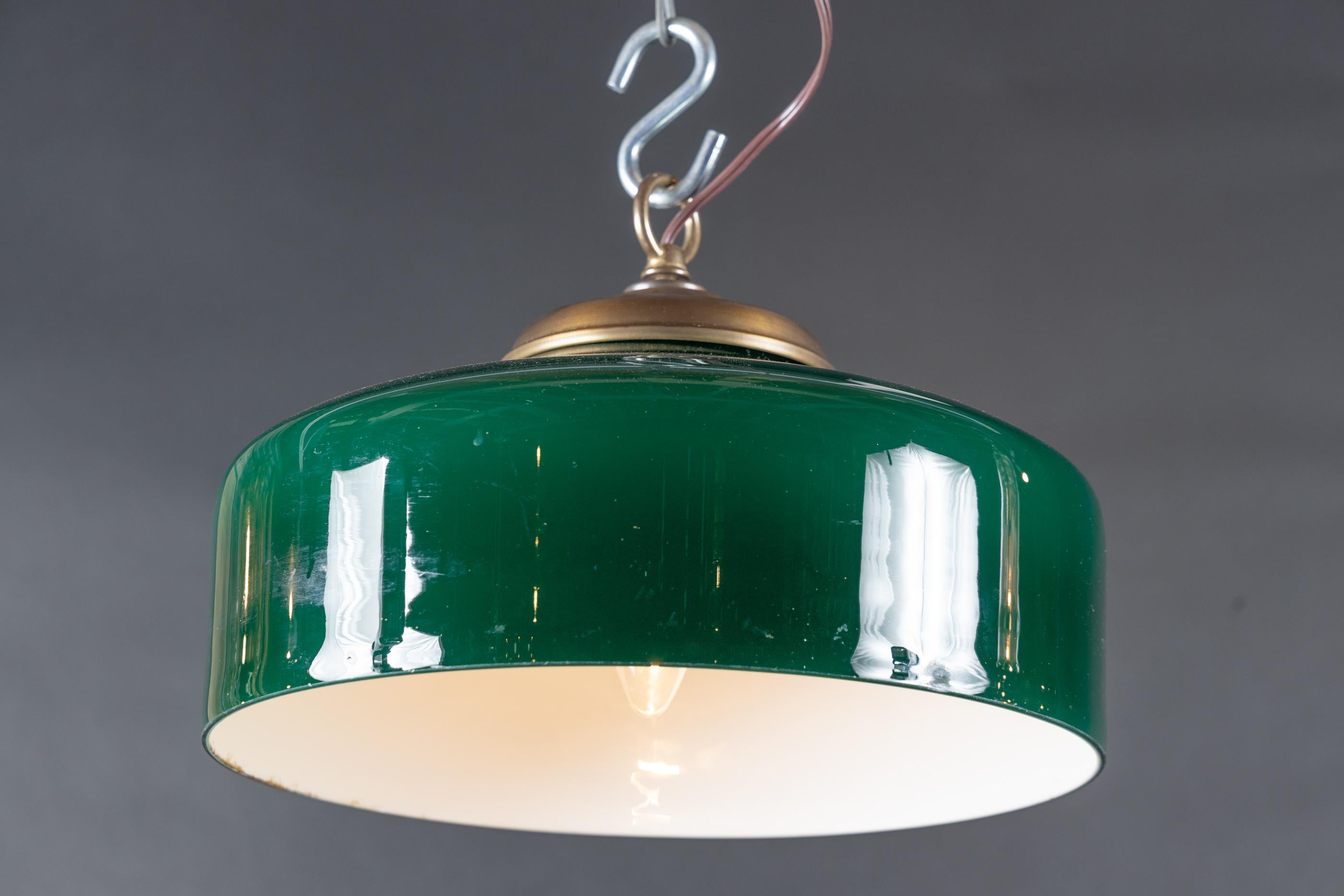 A beautiful hanging lamp from France made in the mid 20th century. The piece features a fantastic deep green glass alongside brass fittings. The glass provides a beautifully tinted light and gives a delightful ambiance to any room.

