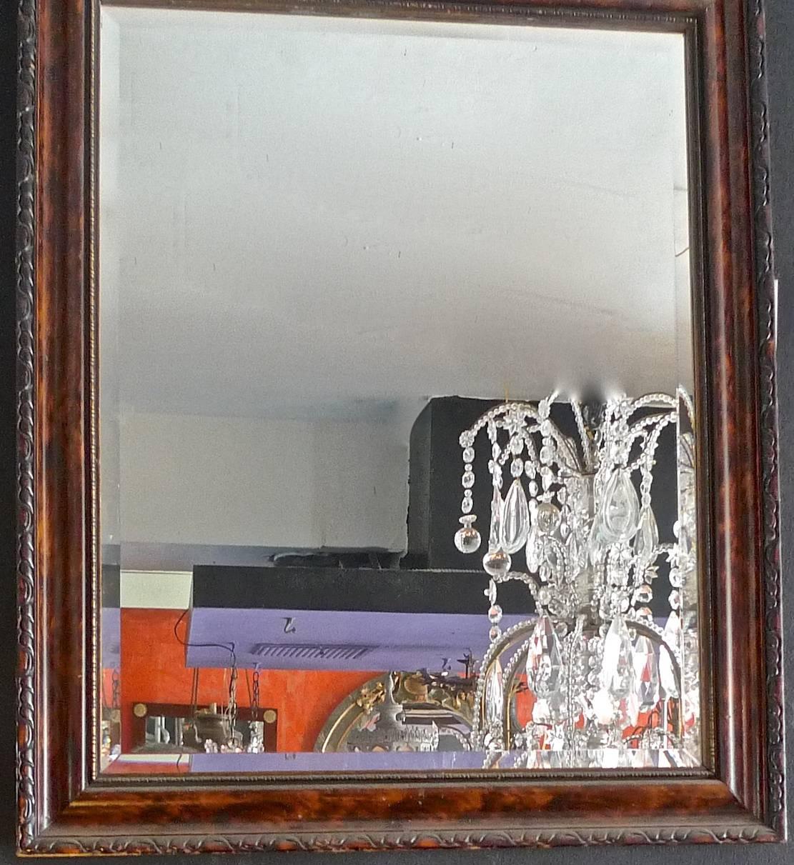 French mid-20th century hand craved walnut and mahogany framed beveled mirror.