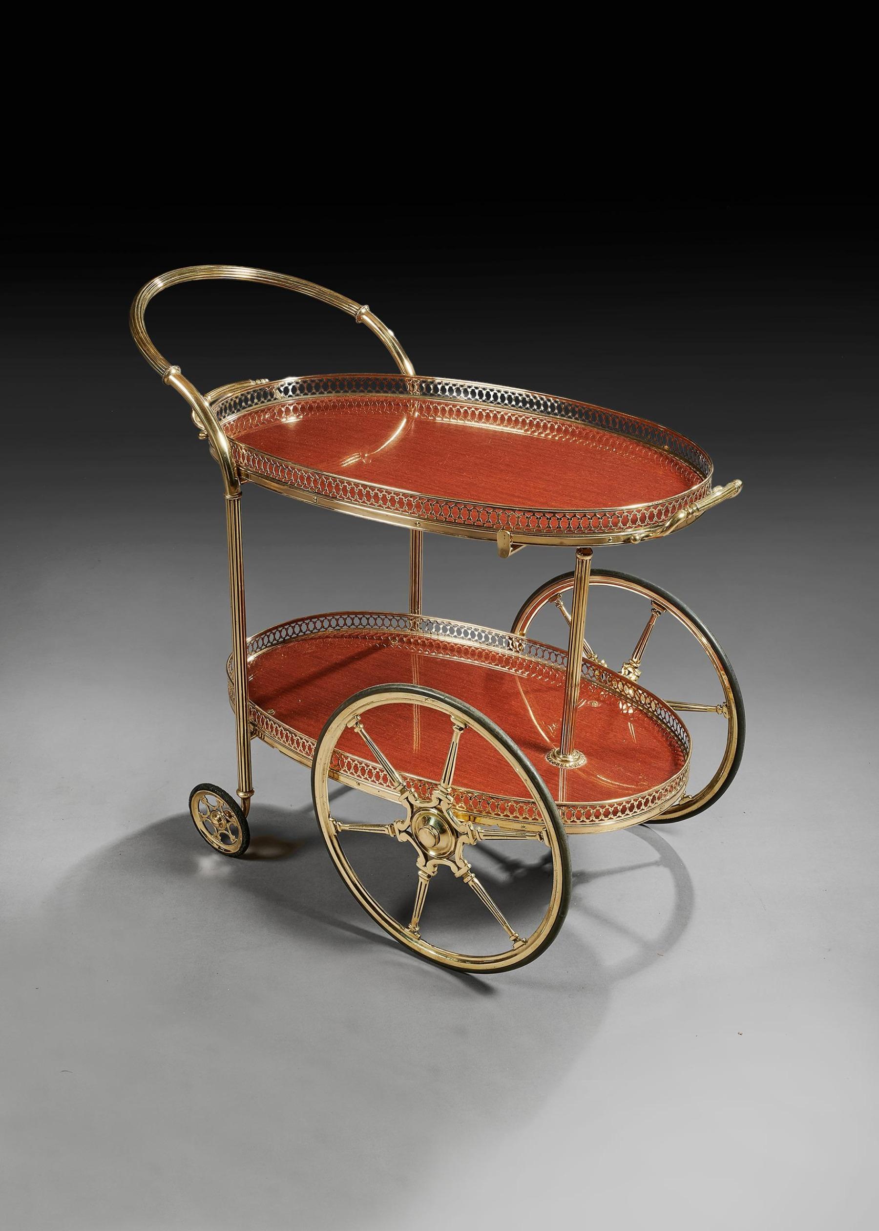 A French mid-20th century brass oval bar cart with removable tray, circa 1960.

Of very good quality, the polished brass removable top having a pierced gallery and reeded carrying handles boarding mahogany formica tray supported by reeded central