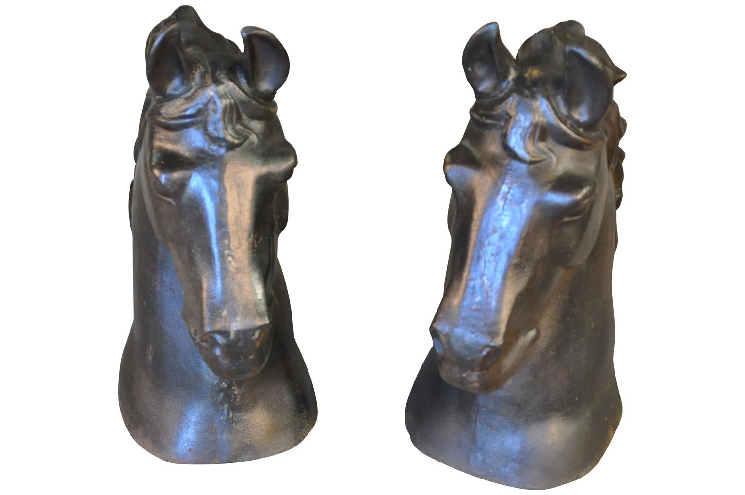 A very impressive pair of French mid-20th century horseheads beautifully cast in patinated iron. Terrific accent pieces for any bookcase, mantel, tabletop or garden accent.