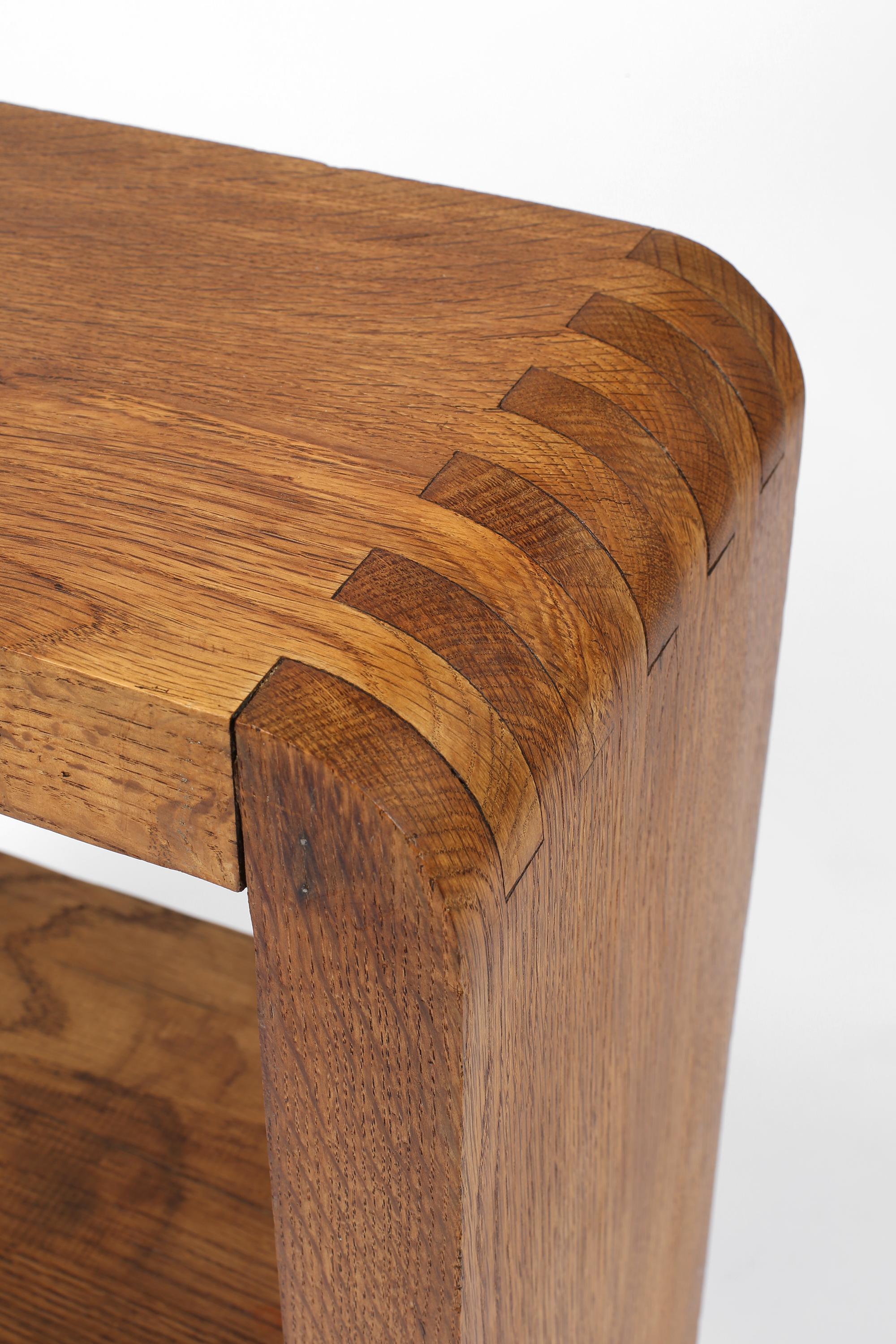 A smart, mid-20th century side table or small console in solid oak, with lower shelf and attractive, visible joinery. In the manner of Pierre Chapo.