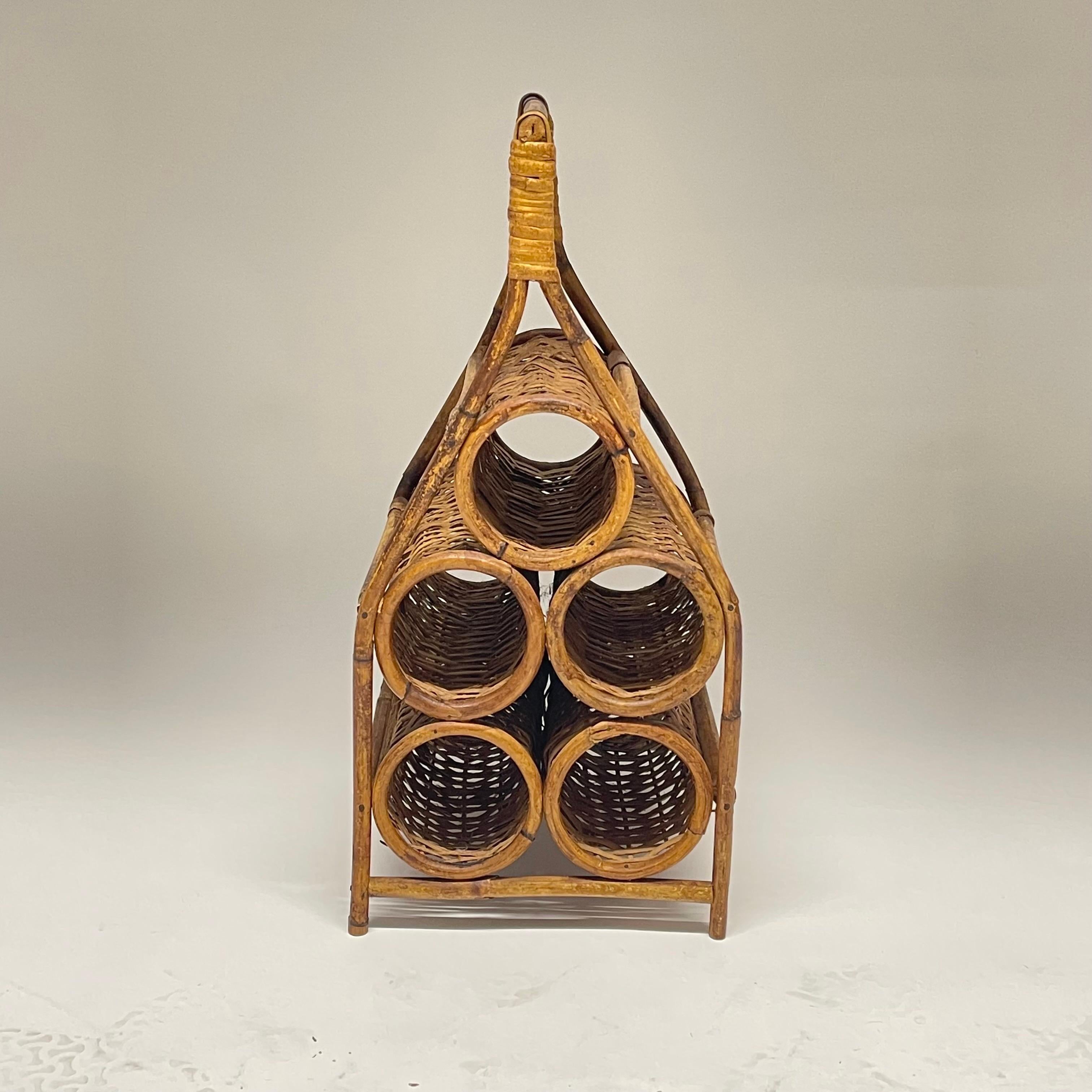 Sculptural midcentury French wine rack or wine holder, rendered in hand woven wicker, and hand bent rattan and bamboo with capacity to hold up to 5 bottles of wine with a handle for transporting if necessary. Made in France, circa 1960s.