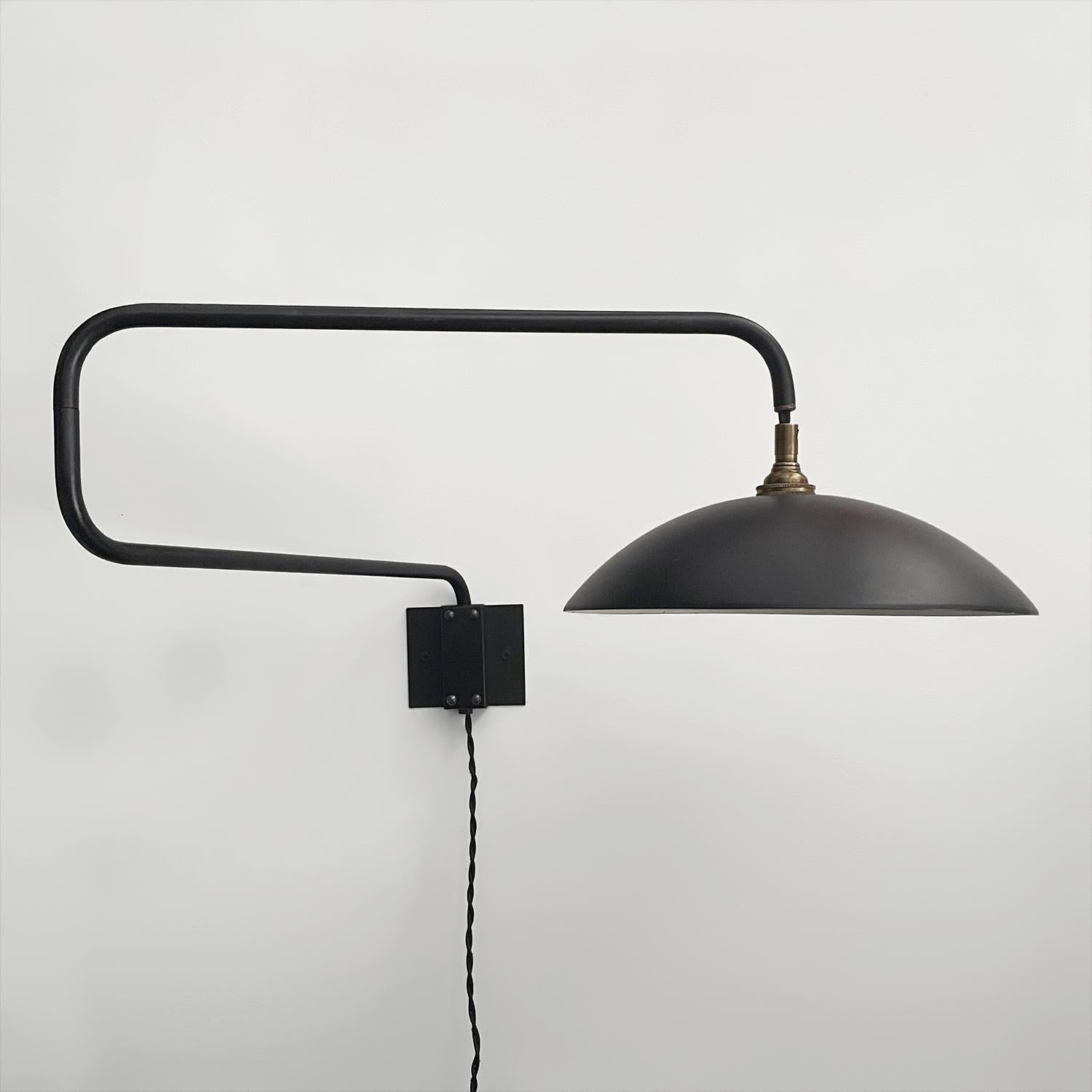 Aplique articulado de contrapeso francés
Francia, hacia 1950
El marco en zig zag de metal tubular negro mate puede utilizarse en diversas configuraciones
La pantalla pintada en dos tonos tiene detalles de latón envejecido y un desgaste menor
Placa