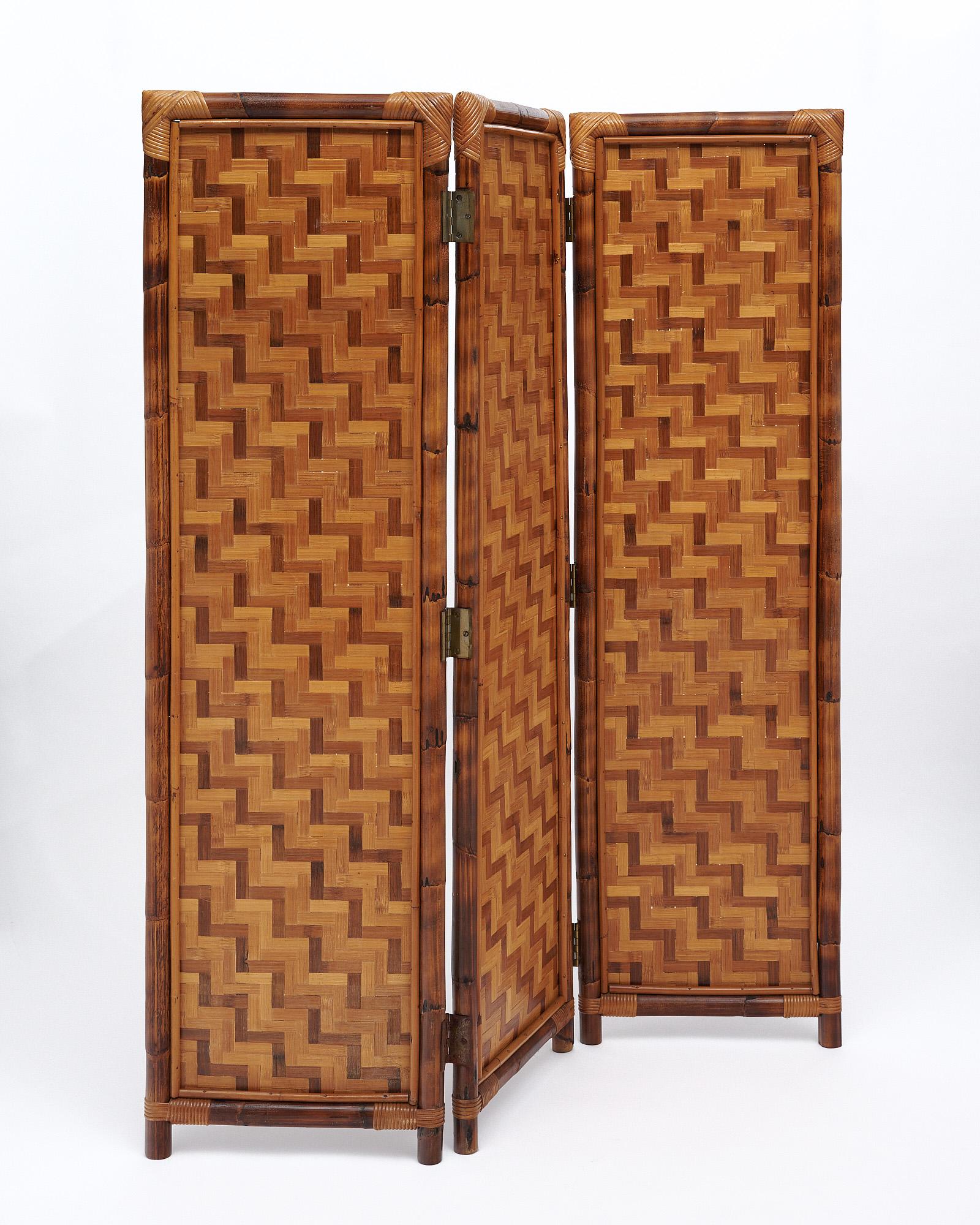 Screen from France in the mid-century style. This piece is made with a bamboo structure and striking rattan screens with a woven pattern crafted from the color tones of the rattan.