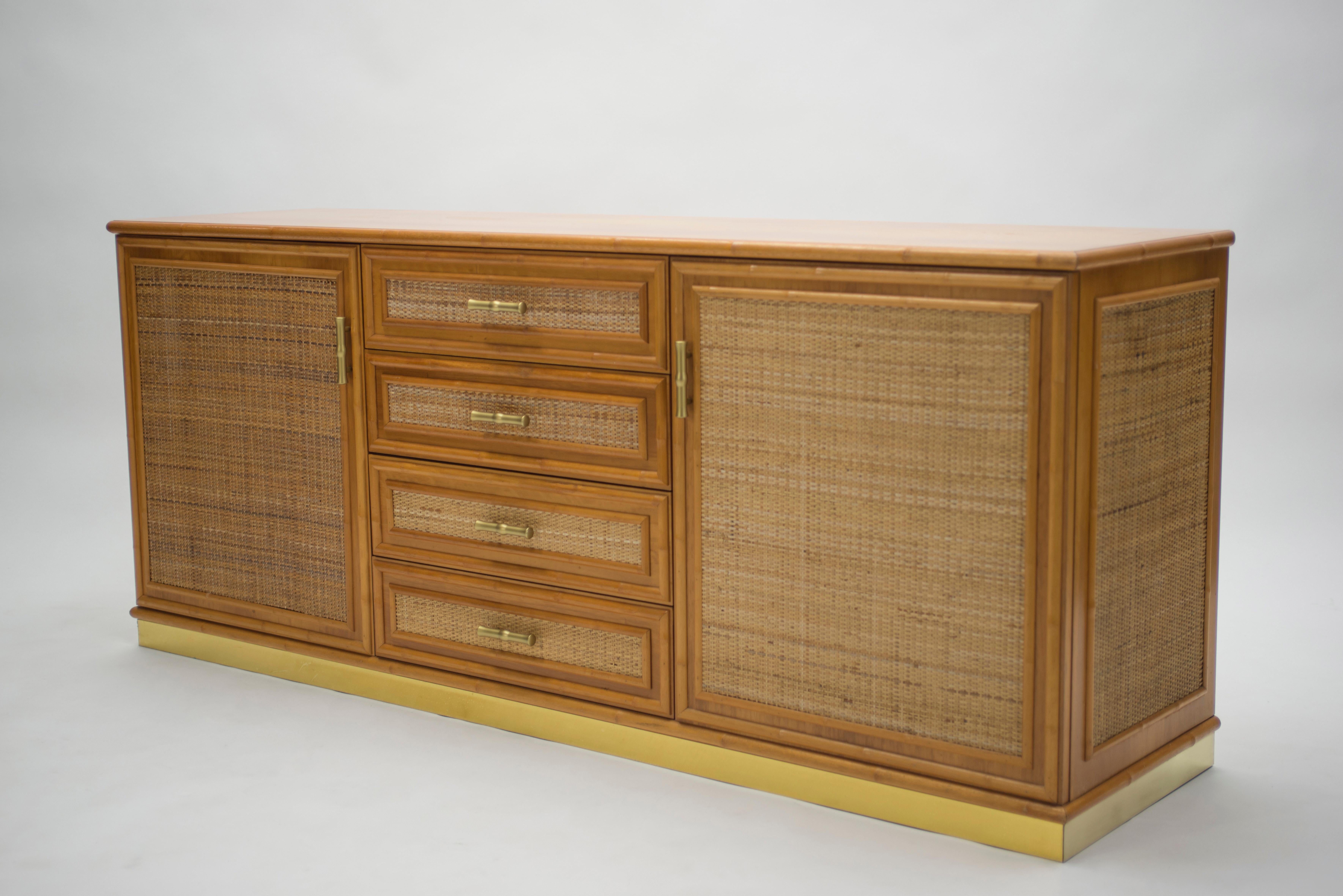 Natural bamboo as the chief material creates a summery, organic aesthetic in this 1970s sideboard, while a bright brass base and accents are strong, eye-catching touches. In particular, the brass handles on the drawers and doors are lovely examples