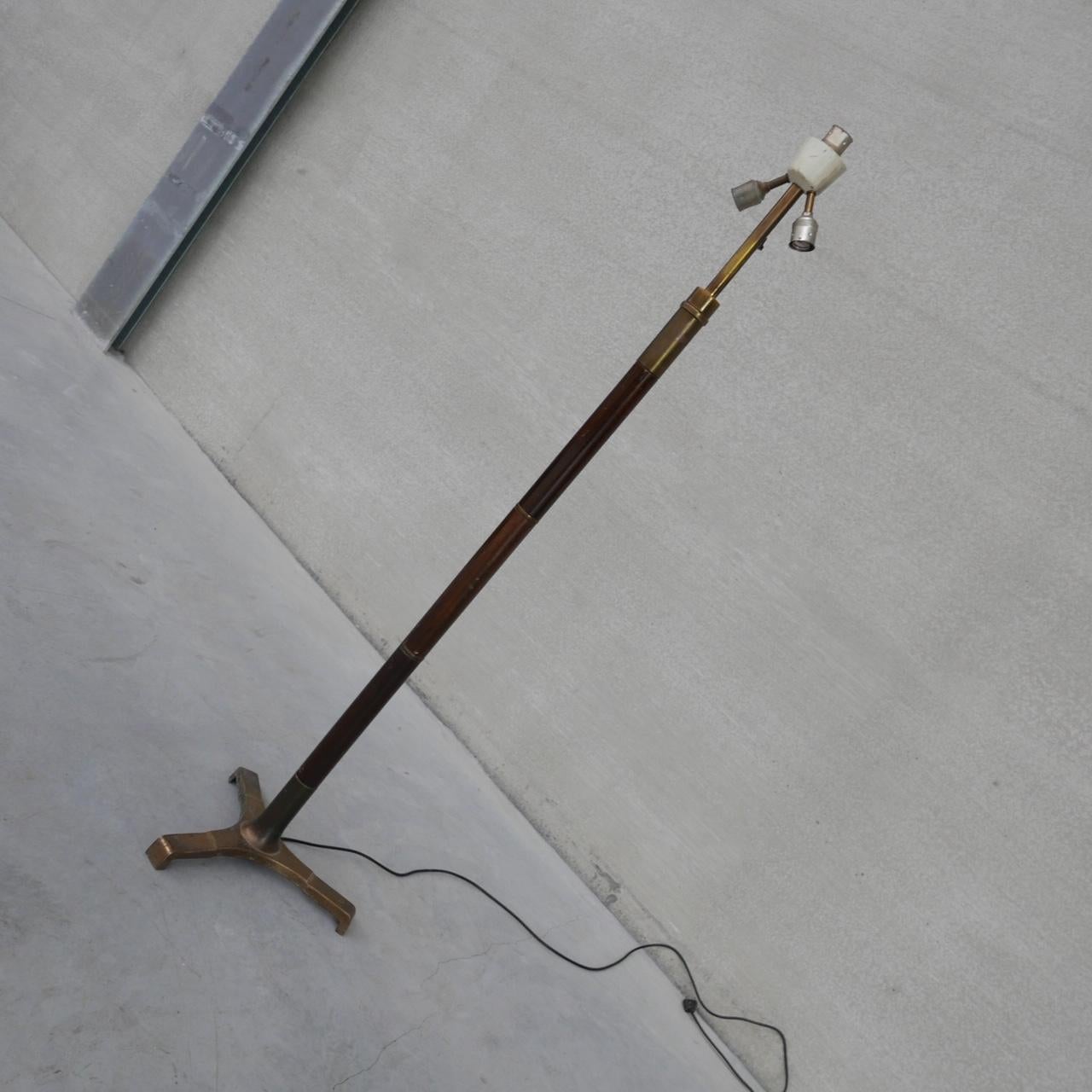 A brass and wooden floor lamp, naturally patinated. 

France, c1950s. 

Heavy and good quality. 

Tripod feet. 

Natural patination which could be made shinier depending on taste. 

Since re-wired and PAT tested. 

Some surface wear