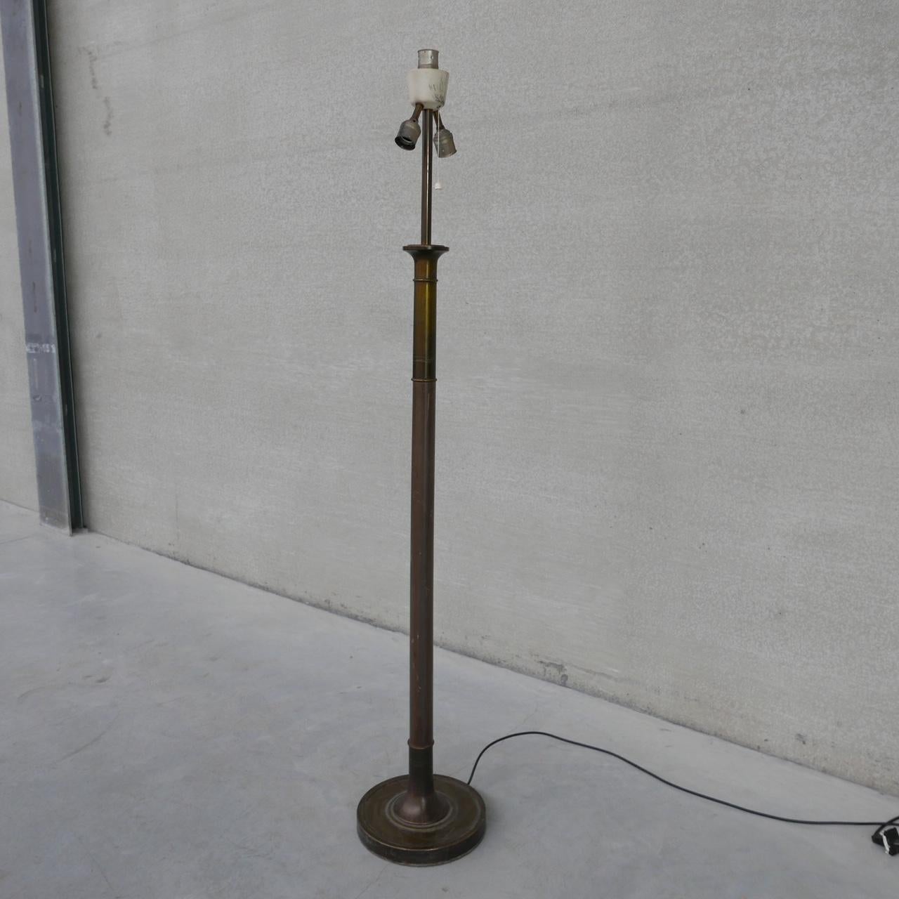 A brass floor lamp, naturally patinated. 

France, c1950s. 

Heavy and good quality, possibly part bronze given it's weight. The middle stem looks to be wood. 

Natural patination which could be made shinier depending on taste. 

Since