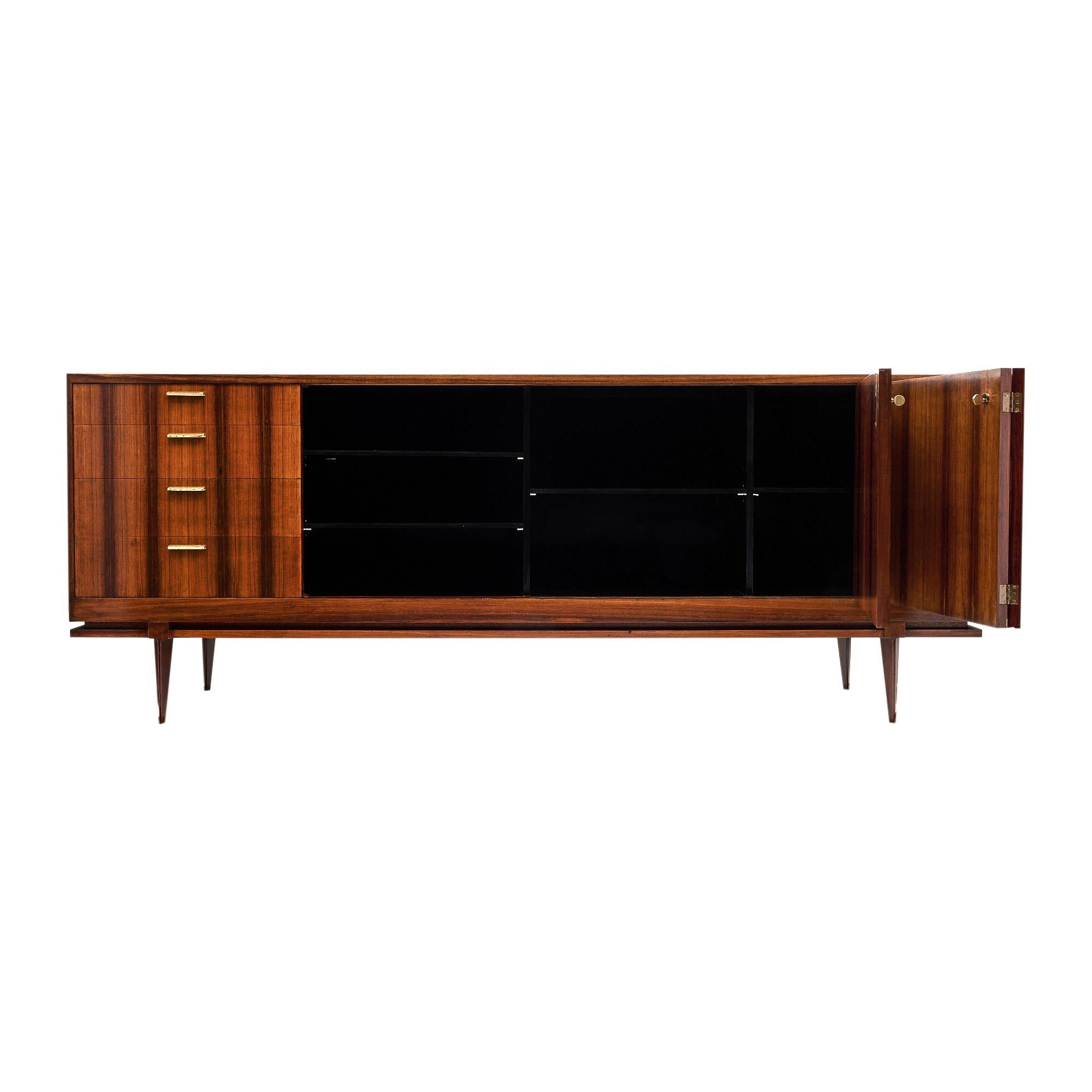 Buffet from the mid-century period in France. This piece is made of solid wood construction and features a striking Brazilian Rosewood veneer. The rosewood has a strong striped pattern throughout. There are four dovetailed drawers on the left side