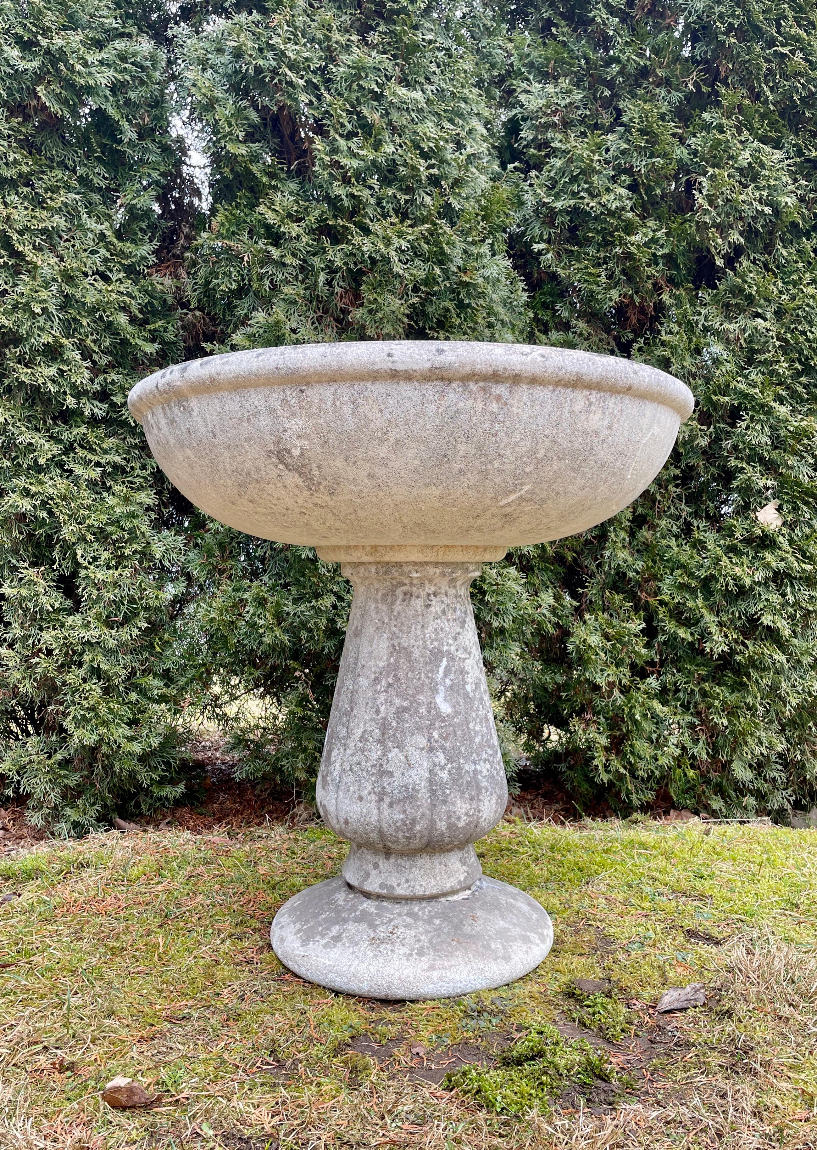 The form and patina on this midcentury French cast stone font are simply wonderful and its uses so varied. In two parts (the riser and foot are separate from the bowl), it can be used as a font, planter, fountain, or fill it with sea shells and