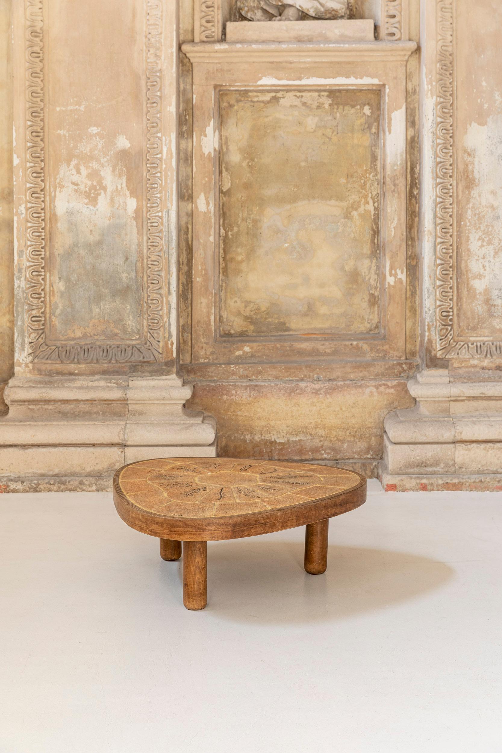A coffee table designed by the French ceramist Barrois with a bend wood frame and a tile top finely decorated in a triangular shape, mounted on three turned legs.