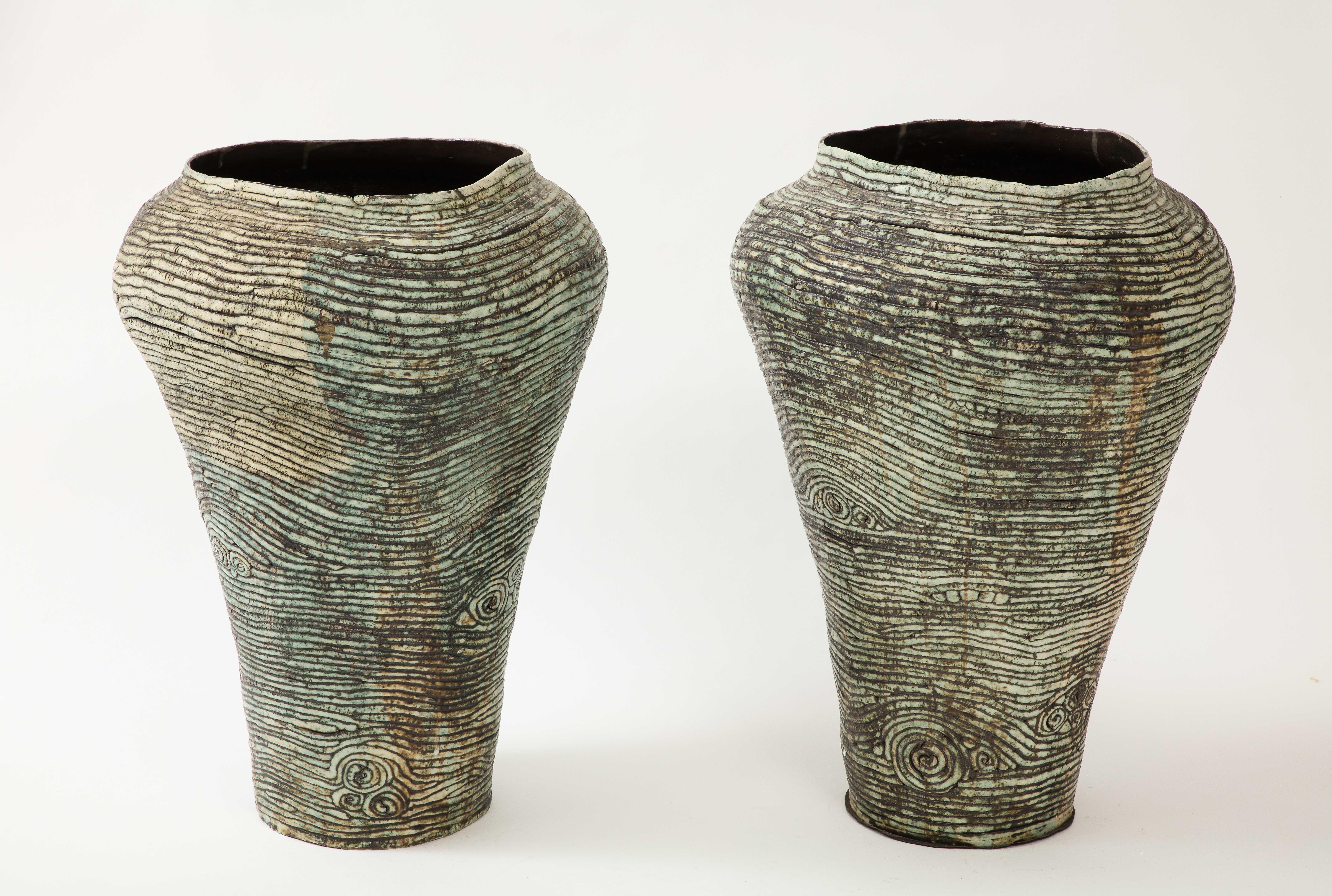 Pair of large scale hand built ceramic pottery vessels featuring bone white and green matte glazes.