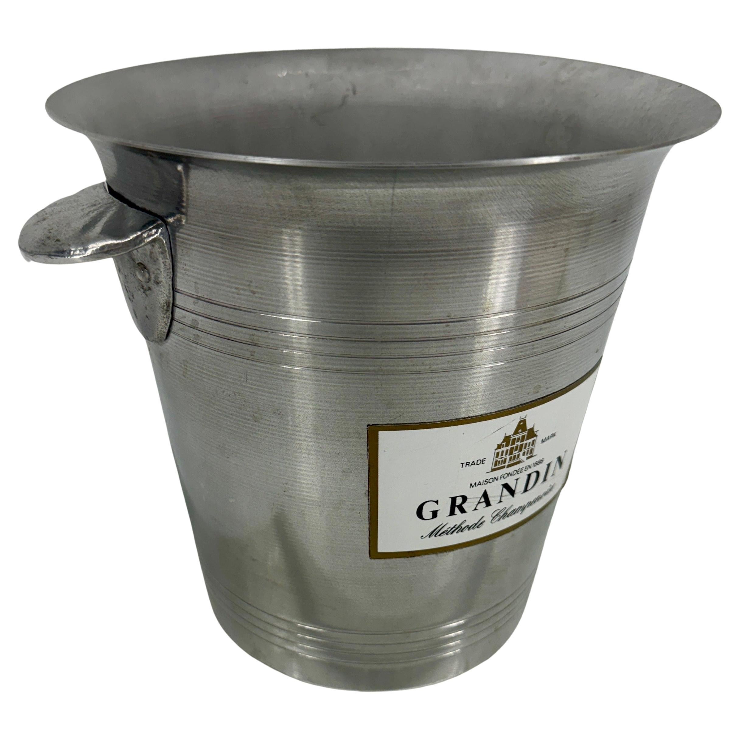 Seau à glace pour champagne, Vintage By France, 1950

Ces seaux à champagne en aluminium provenant de France ont été utilisés dans les années 1950 et 1960 et portaient généralement le nom du viticulteur. Celui-ci est étiqueté GRANDIN. Ces