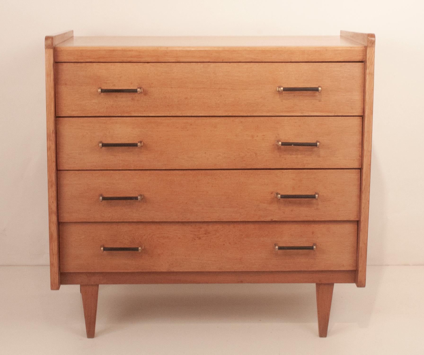 Mid-Century Modern Mid-Century French chest of drawers in oak with black and brass handles.