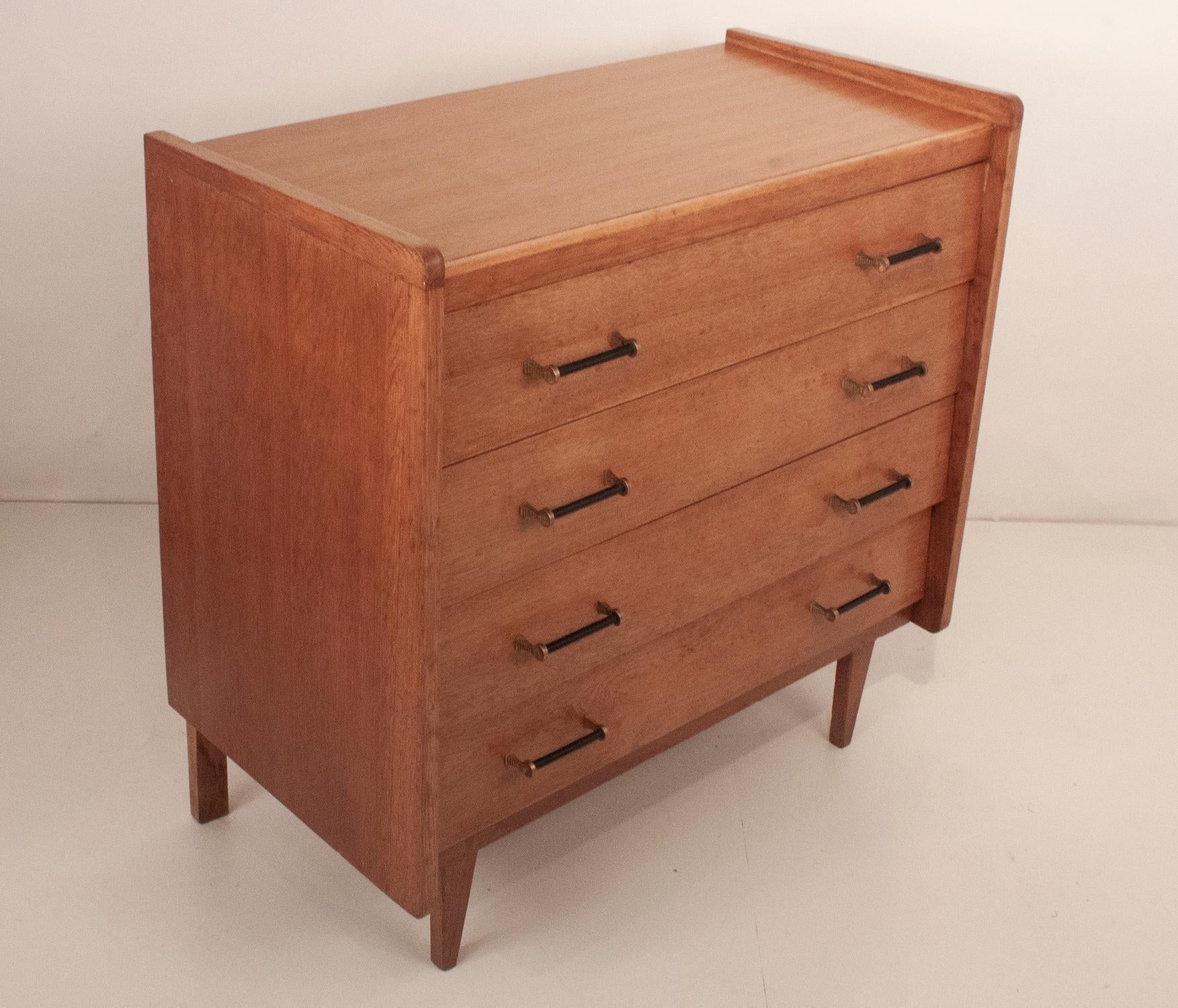 Oak Mid-Century French chest of drawers in oak with black and brass handles.