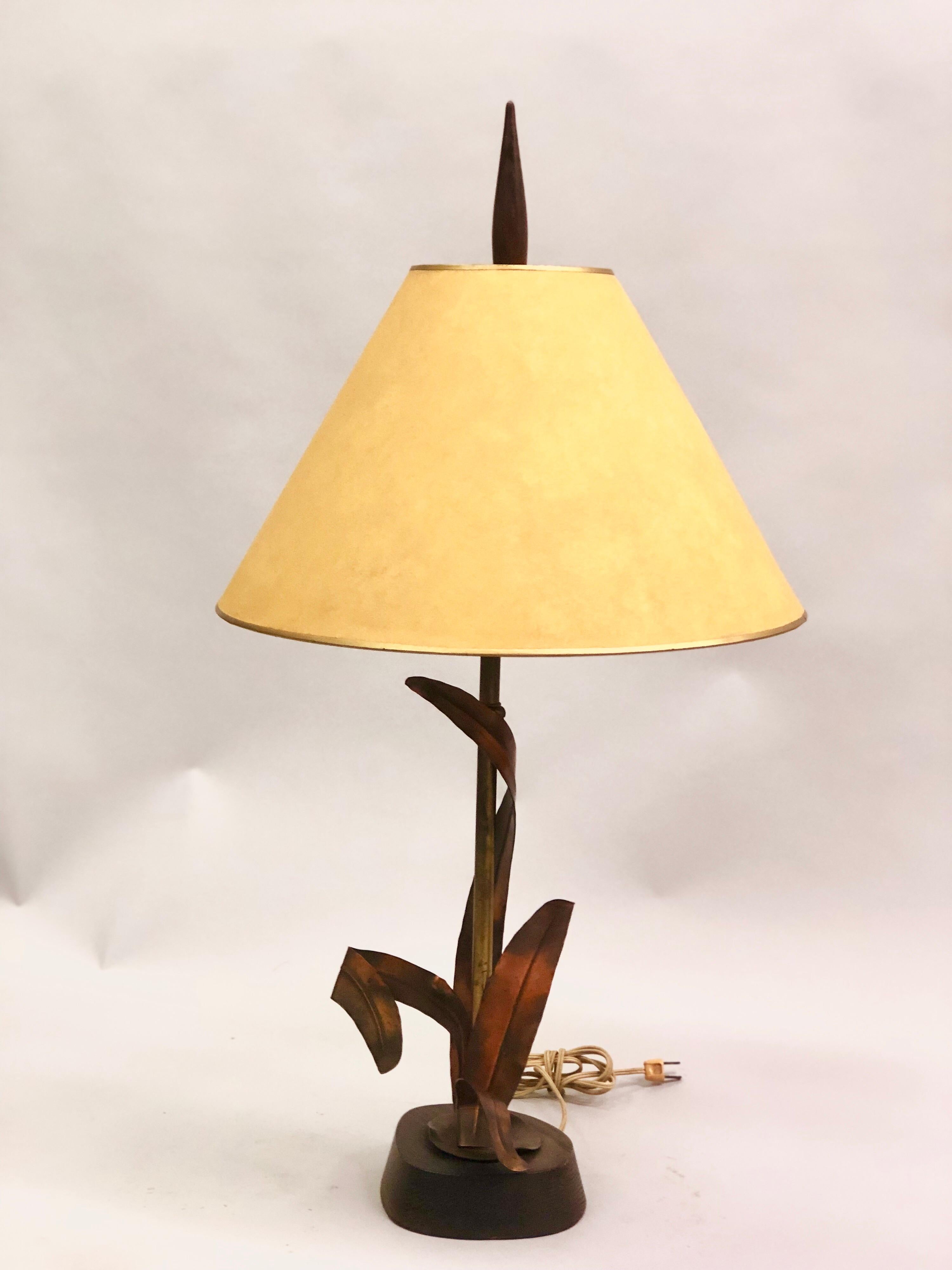 French Mid-Century Modern copper, bronze and brass floral table lamp by Maison Charles et Fils. The copper is elegantly formed to wraparound a brass stem. Base and tapered finial are composed of wood.  Measurements: Diameter of lamp itself is 8
