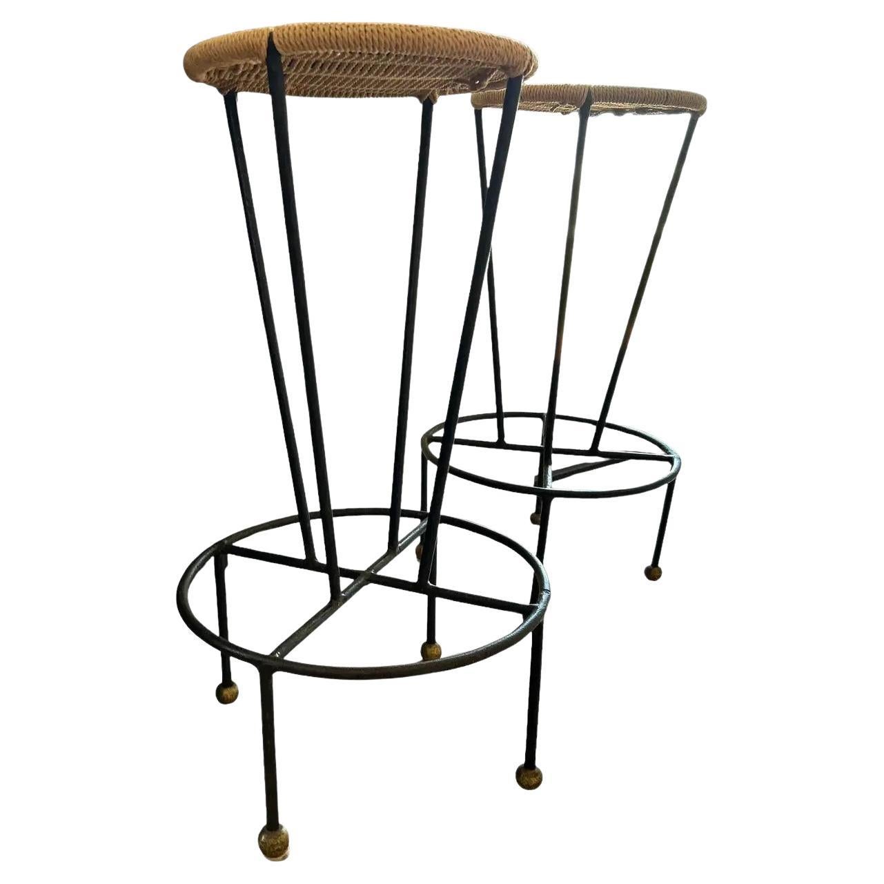 Tres taburetes de bar únicos de hierro y junco de mediados de siglo. Estos taburetes únicos se compraron en la subasta Christie's a la estimada colección de Norah y Norman Stone. Fue adquirida a Christina Grajales, Inc. con sede en Nueva York, por