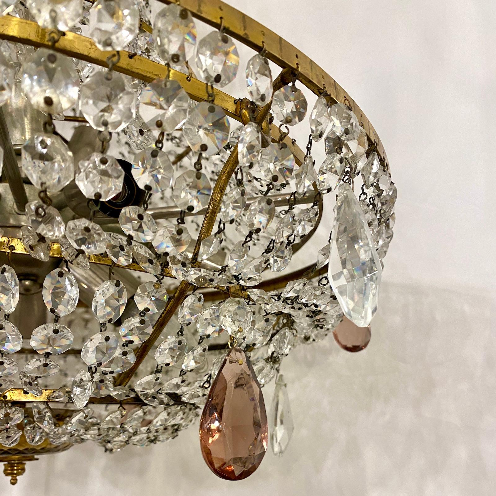 A circa 1950's French crystal and gilt metal chandelier with twelve interior lights and molded glass canopy.

Measurements:
Drop: 28