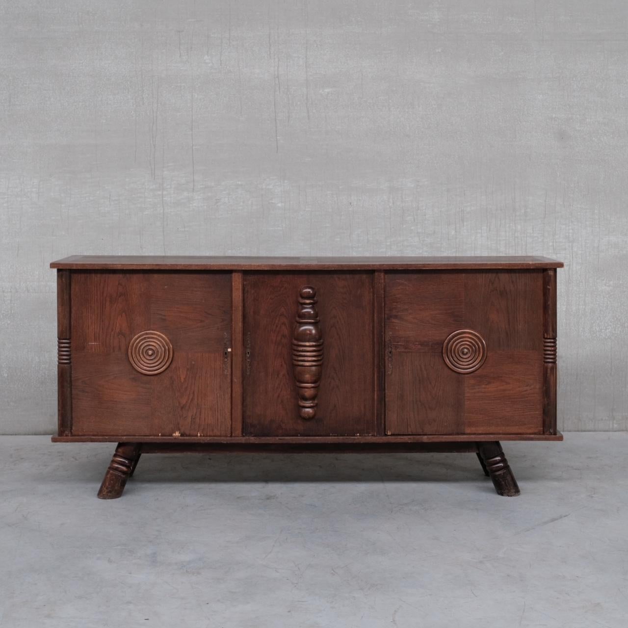 A large sideboard in the manner of Charles Dudouyt. 

France, c1940s. 

Solid oak and oak veneer. 

The cabinet has suffered some wear over the years, but is being restorered by our in house restorer, so please request photos of the updated