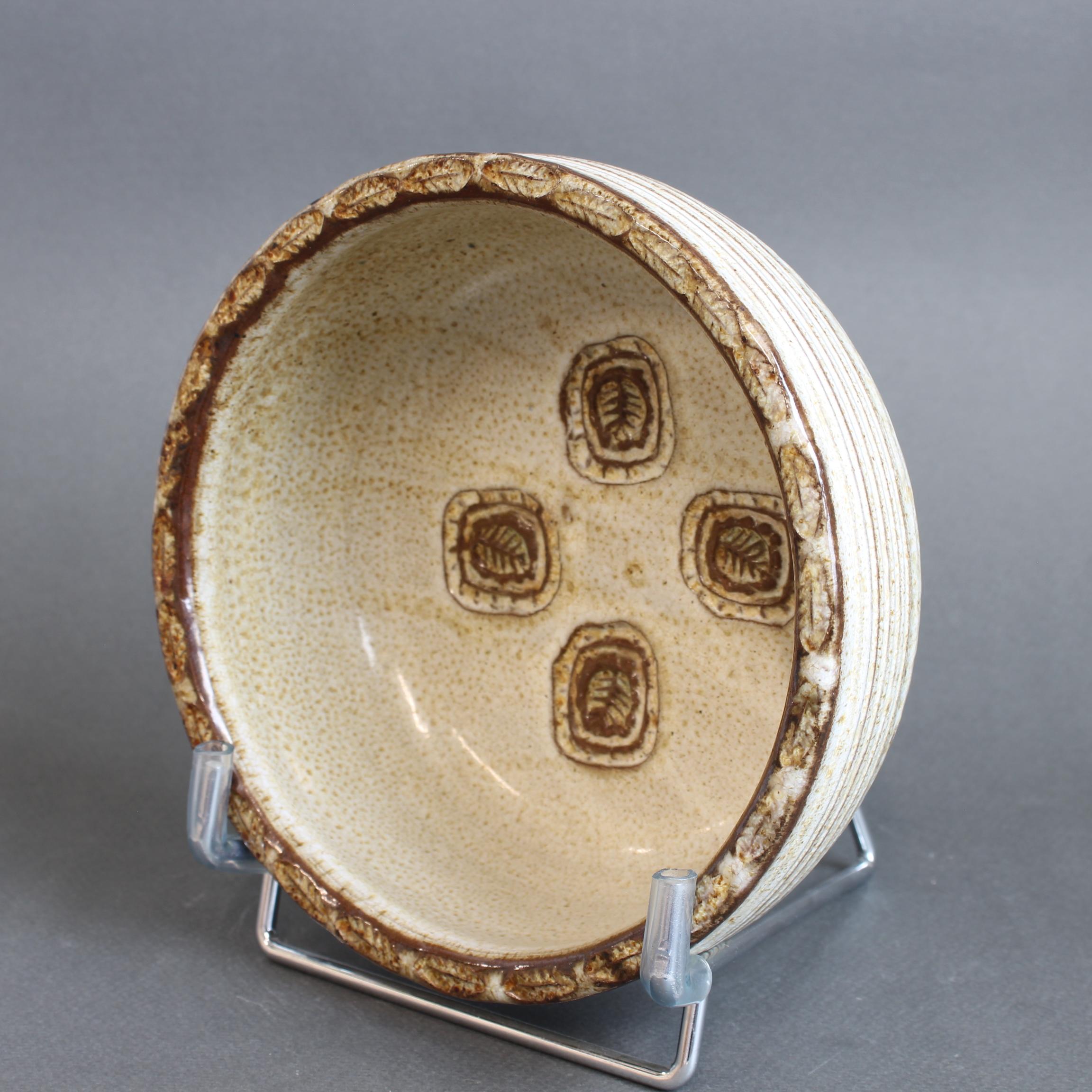A delightful mid-century decorative bowl by French ceramicist Marcel Giraud, dating from the 1960s. The design features a rustic, even-glazed base and wall in oatmeal accented tones. Incised at the base are four small, rounded rectangles with inner
