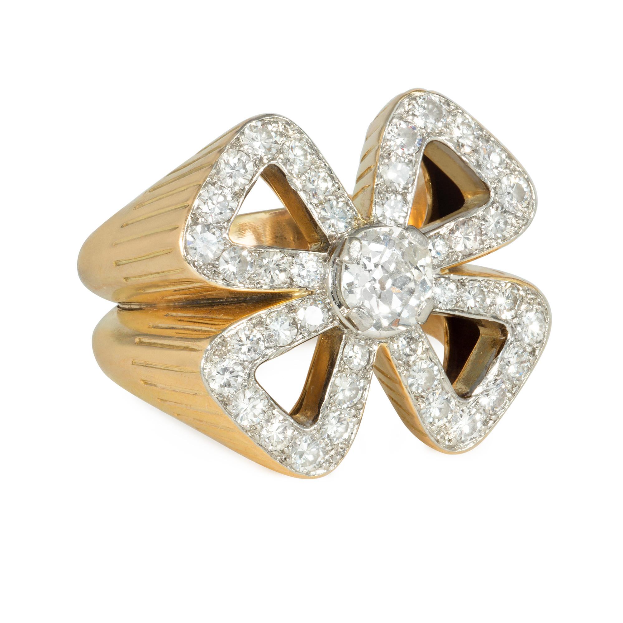 A mid-century gold and diamond cocktail ring, the diamond-set top designed as a stylized openwork quatrefoil or four-leaf clover, centering on a cushion-cut diamond, in 18k with a reeded pattern on the mount.  France.  Atw 2.49 cts. (center diamond