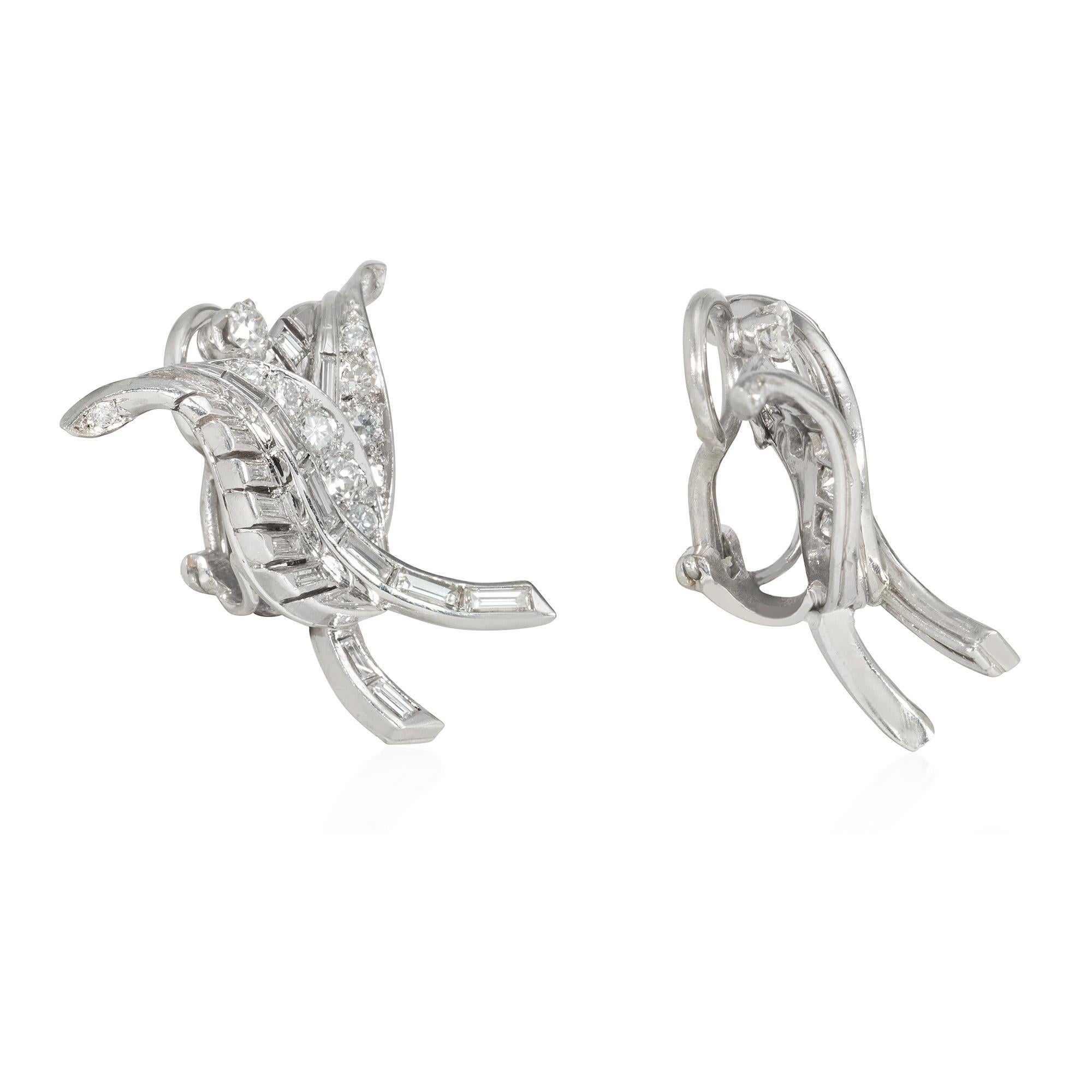 A pair of mid-century diamond clip earrings designed as overlapping leaves with curled tips, each leaf blade consisting of round brilliant-cut and baguette-cut diamonds separated by a petiole of graduated baguette-cut diamonds, and surmounted by a