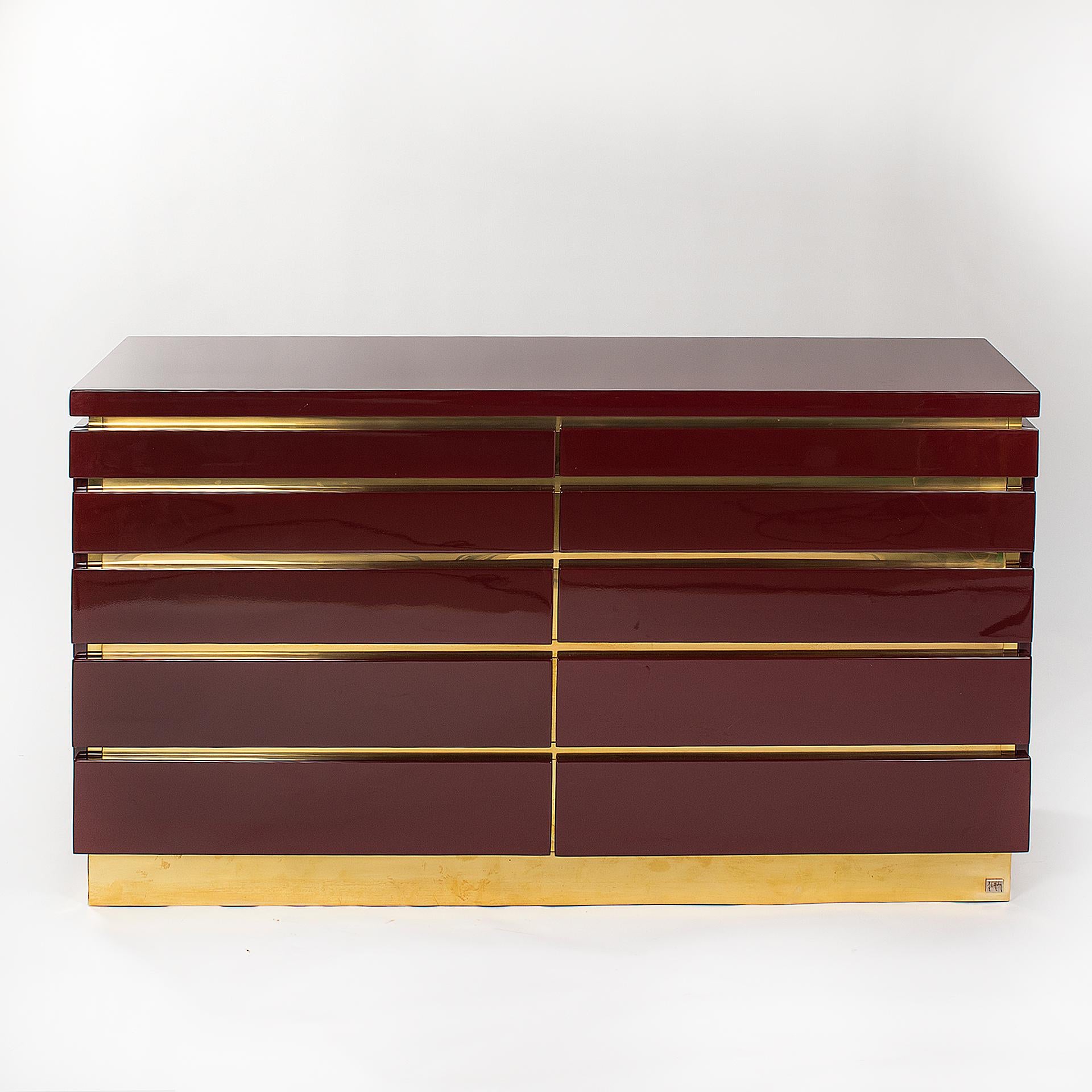 French mid-century chest of drawers by Jean Claude Mahey from the 1970s.
The cubic object captivates with its simple elegance, the lacquering in the color oxblood in combination with the brass details make the object an eye-catcher. 

The object is
