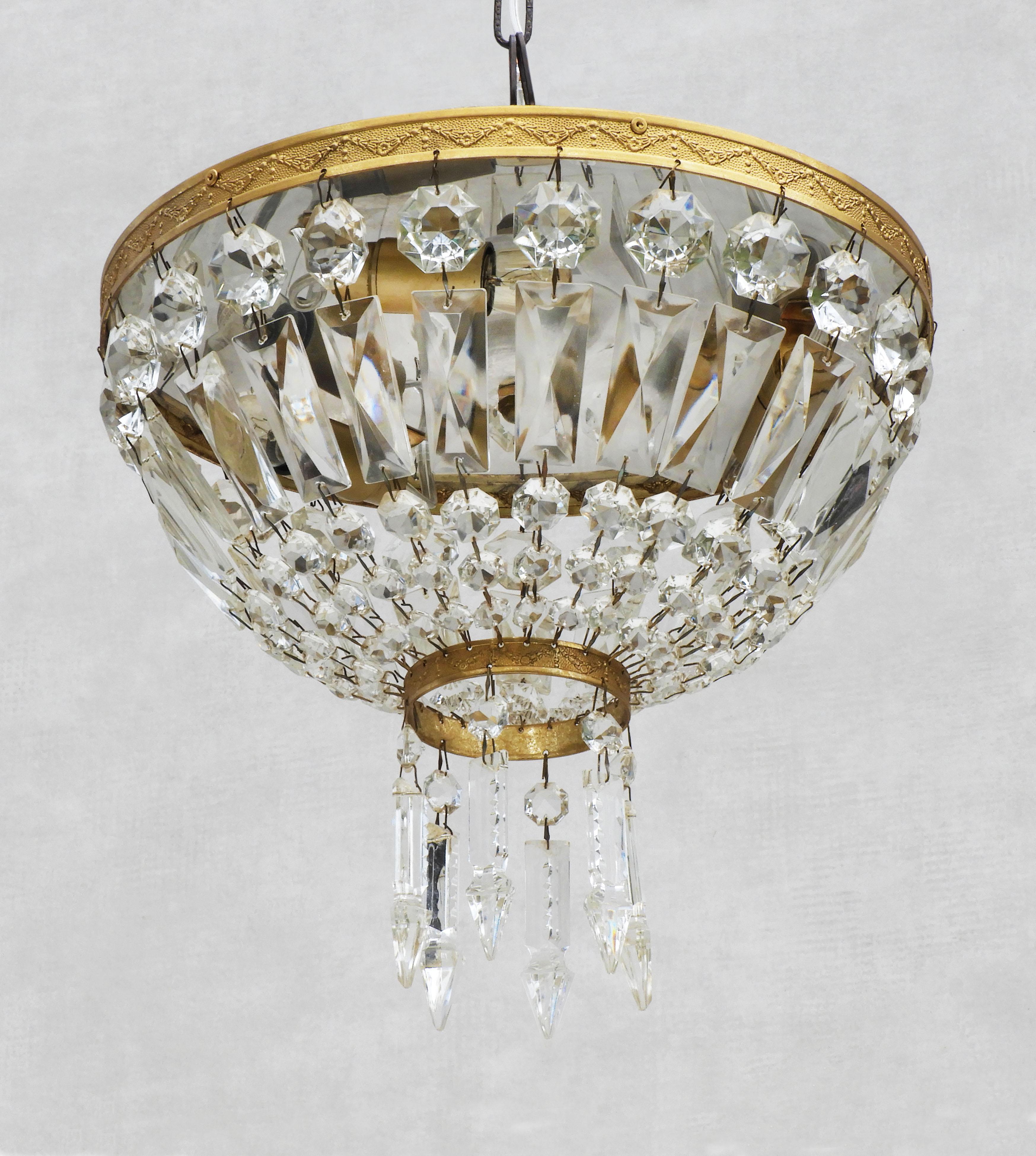 Elegant Mid-20th Century French flush mount chandelier. Multi-faceted strings of octagonal and rectangular crystal cut glass 'pampilles' suspended between gilded circular bands and finished with a fringe of arrow-shaped drops. 
In great vintage